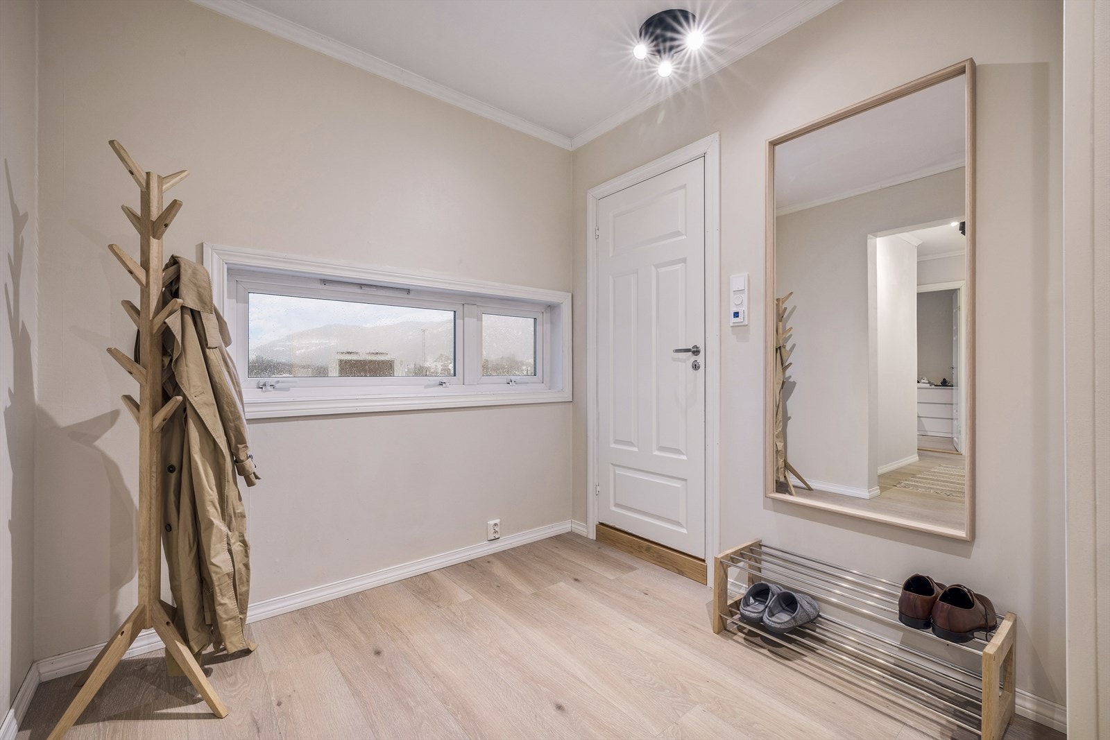 Lys og innbydende entré med speil og praktisk oppbevaringsplass. Perfekt for en varm velkomst til ditt nye hjem. Galleribilde
