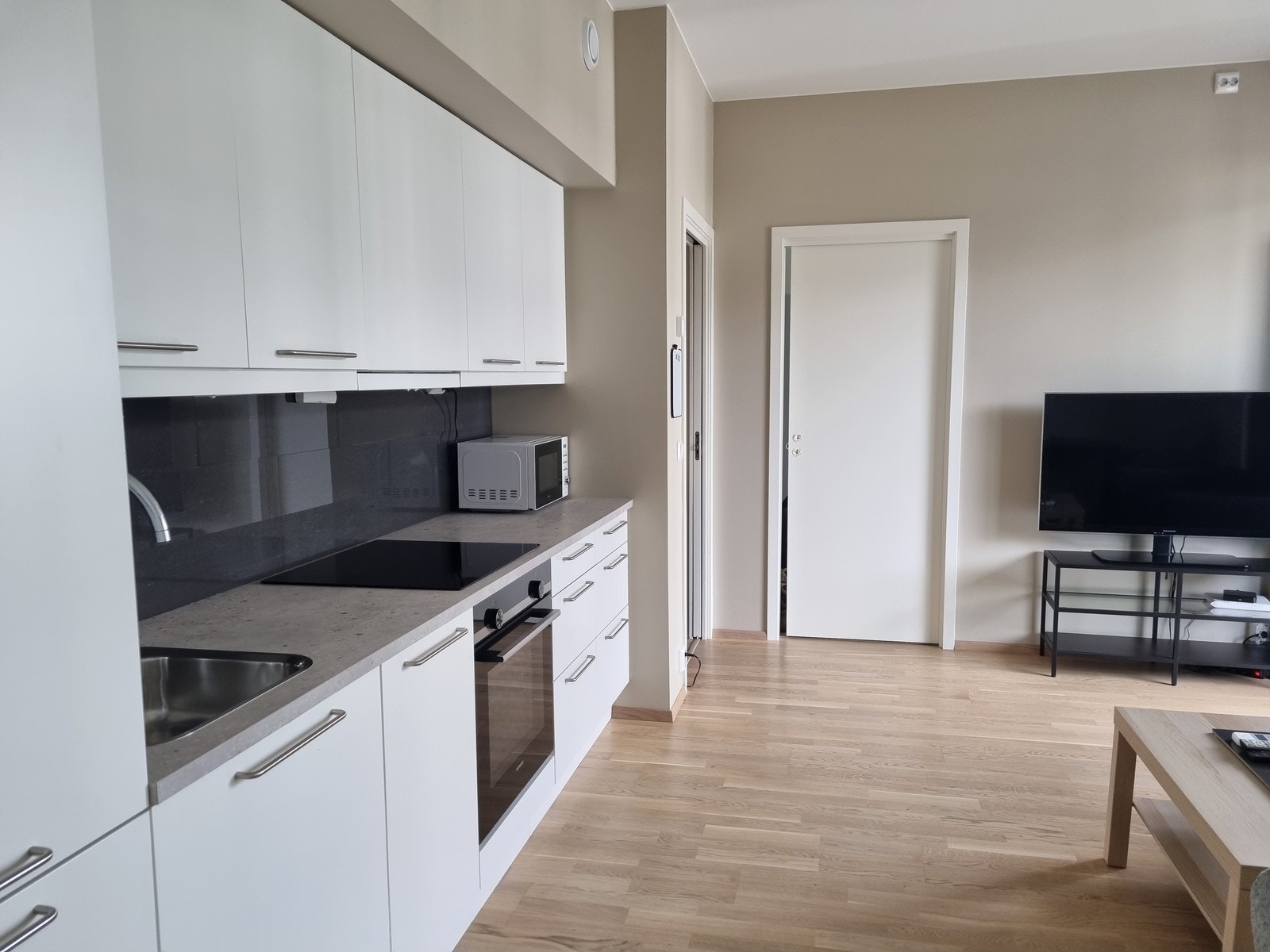 Kjøkken med integrerte hvitevarer og godt med skap- og benkeplass Galleribilde