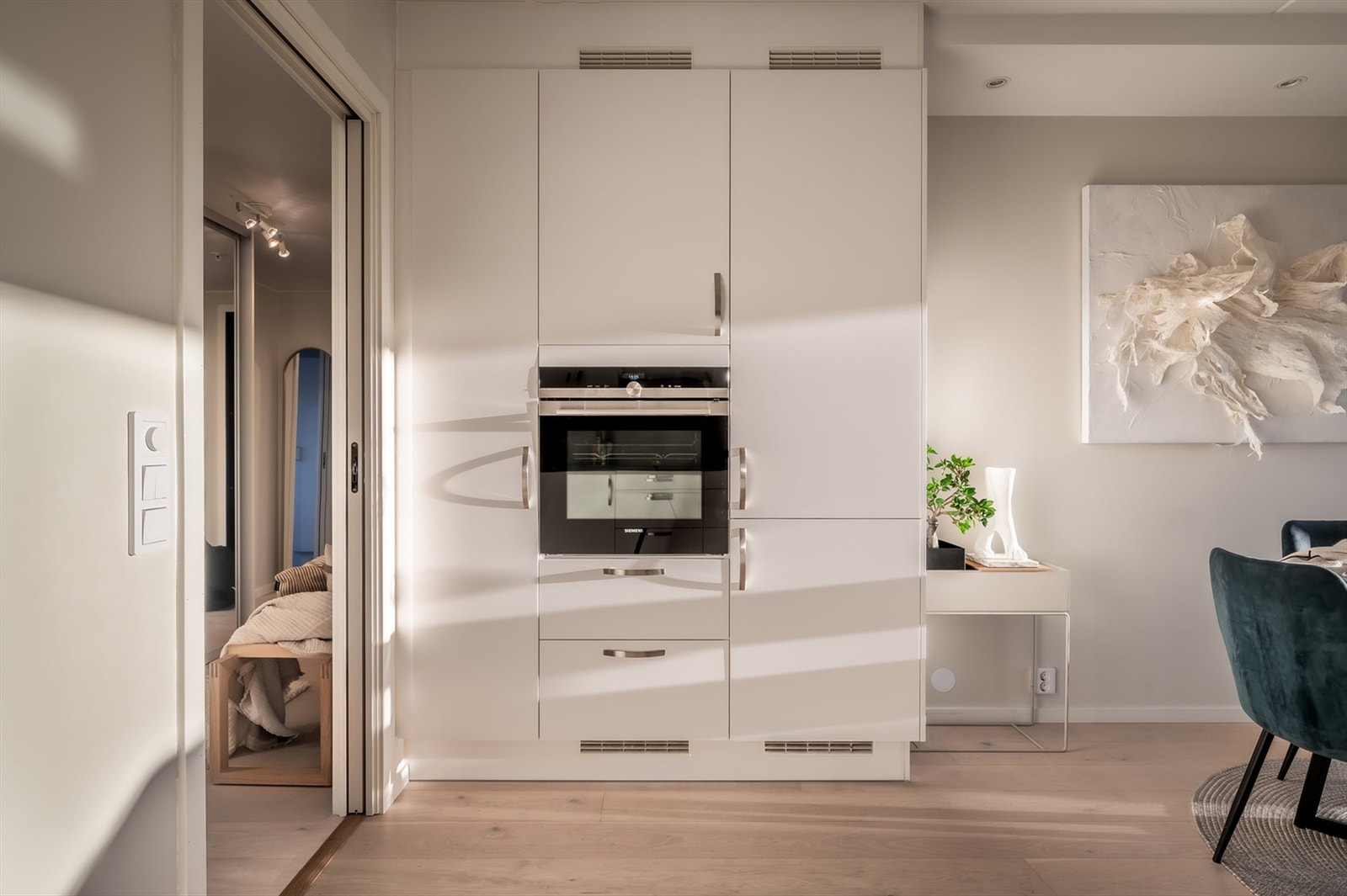 Kjøkkenet består av Integrerte hvitevarer med innfelt platetopp i benkeplate, oppvaskmaskin, komfyr og kjøl/frys. Galleribilde