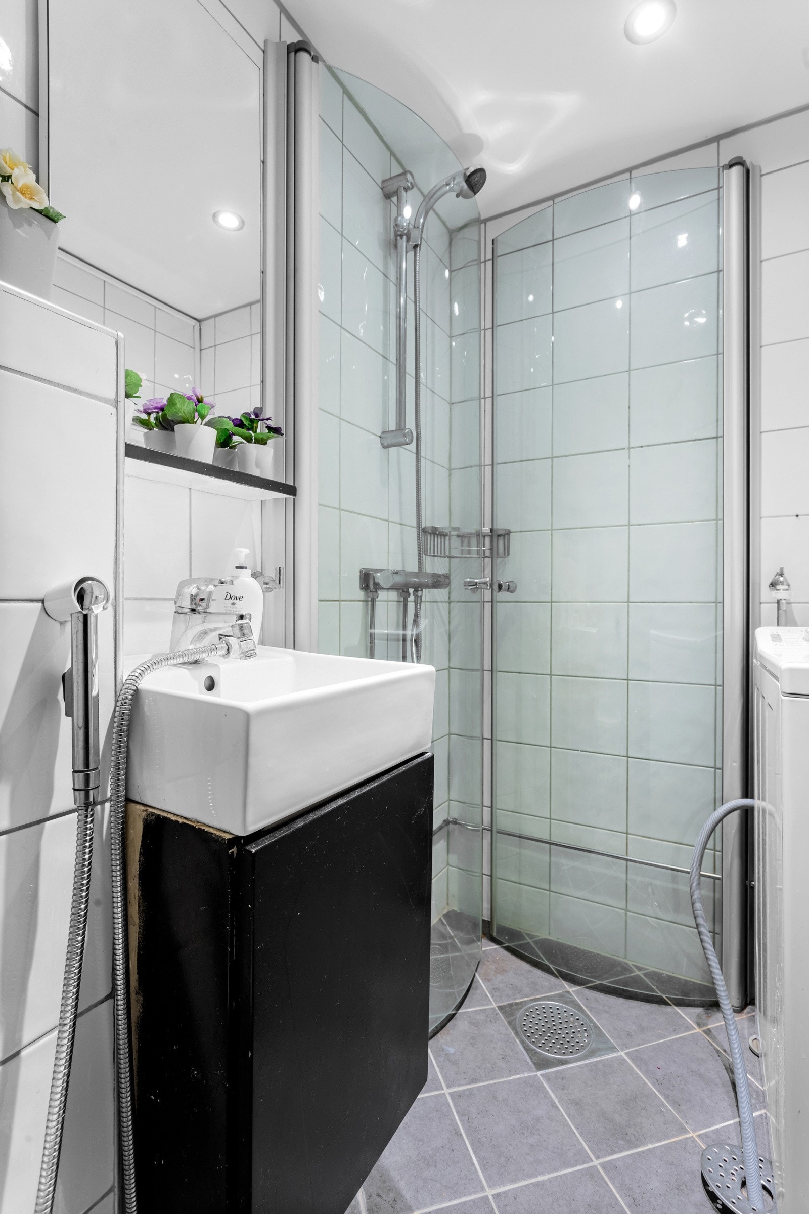 Romslig dusjhjørne med innfellbare dusjvegger for plassbesparelse. Opplegg for smal vaskemaskin. Galleribilde