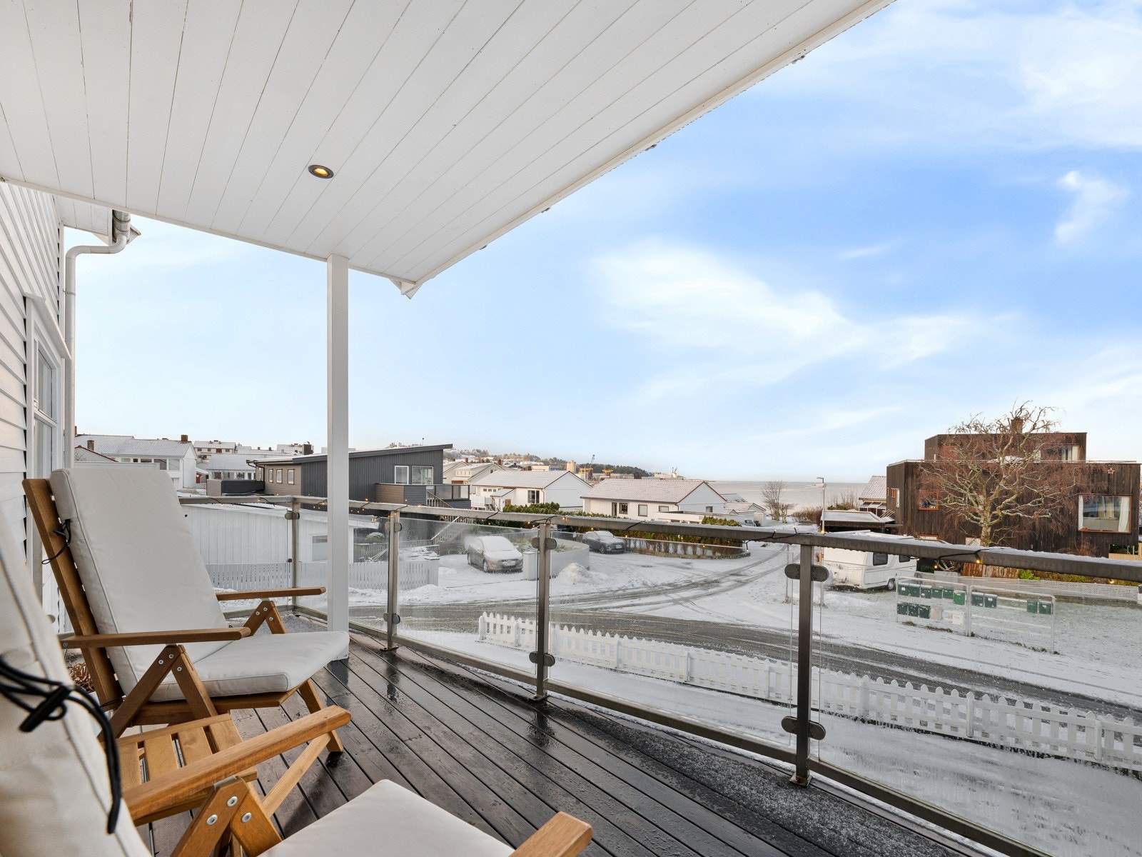 Overbygd balkong med utebelysning og glassrekkverk Galleribilde