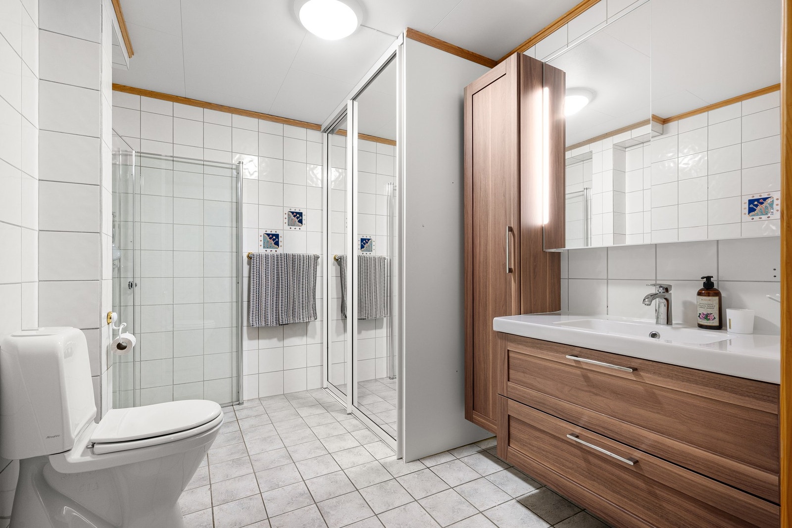 Flislagt bad fra byggeår 1998. Vaskemaskin skjult i stor skyvedørsgarderobe. Galleribilde