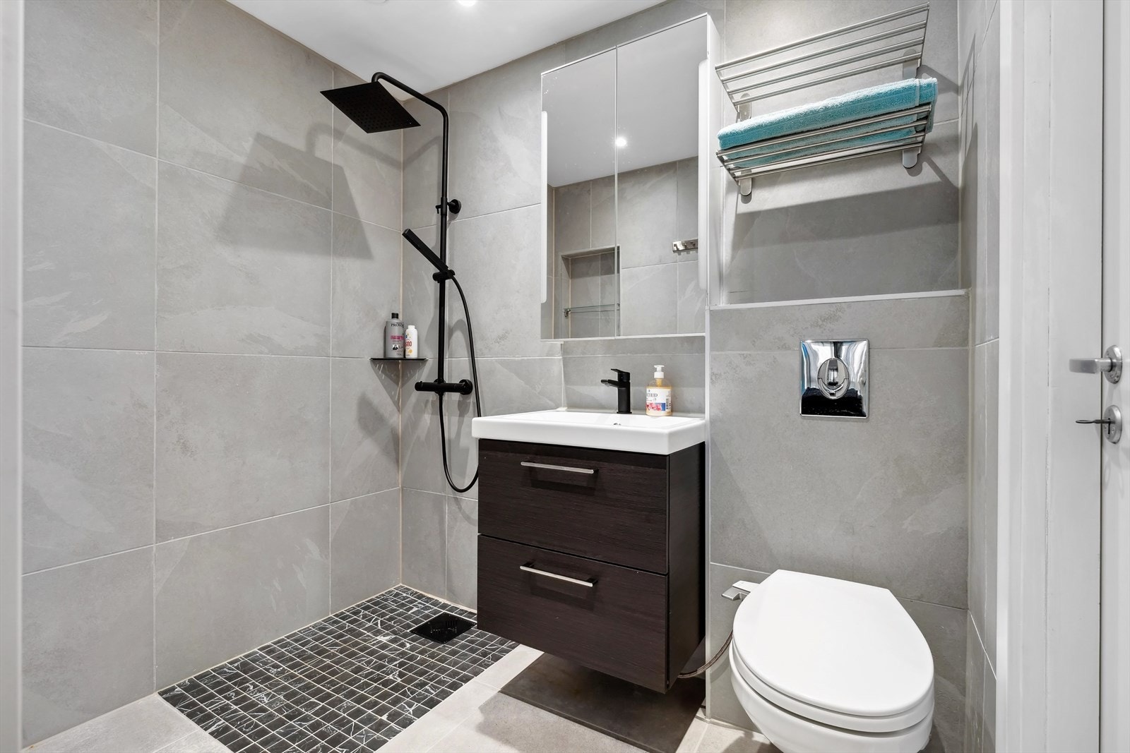 BAD I & II |
Baderom med adkomst fra både entré og soverom: Gulv- og veggflatene består av fliser. Takflatene består av malte takflater. Dusj direkte på gulv med termostat batteri, veggmontert dusjtoalett, servant med skuffer og speilskap med belysni Galleribilde