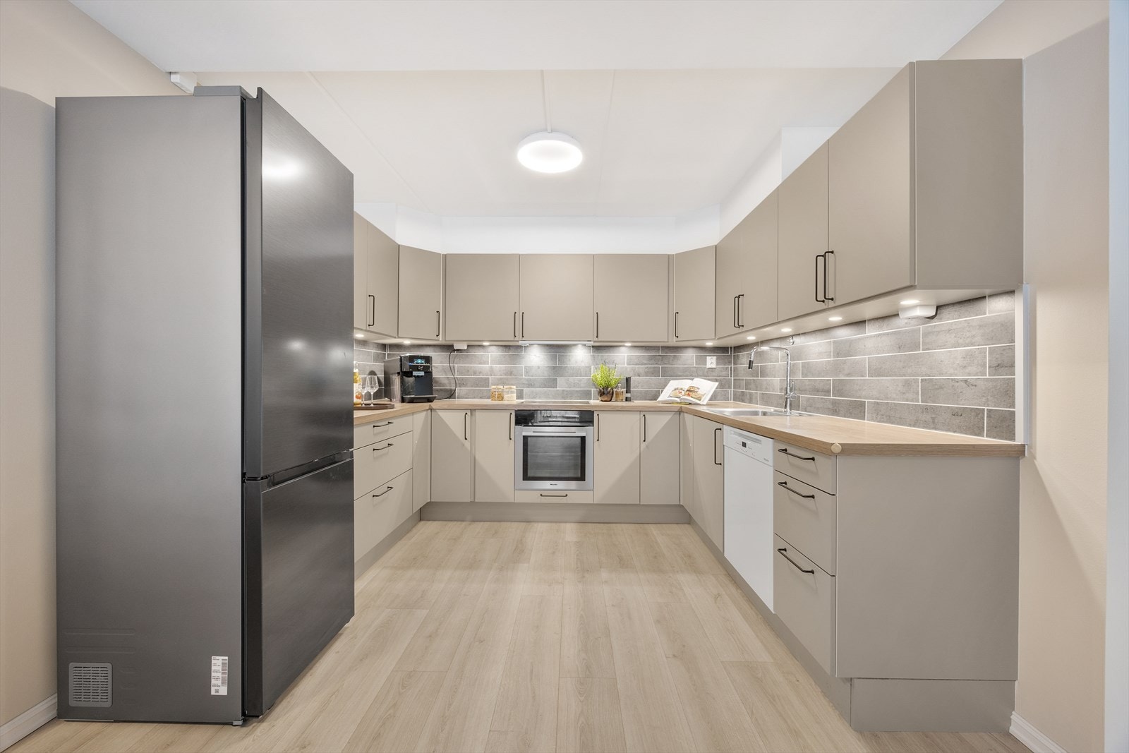 Romslig kjøkken med rikelig skapplass og moderne hvitevarer. Galleribilde