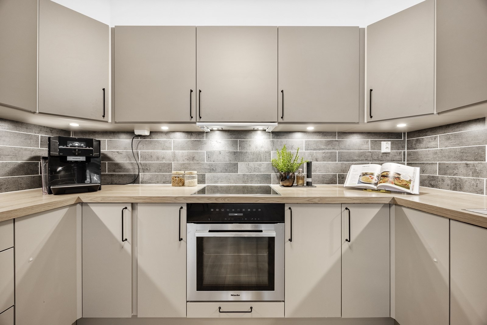 Kjøkken med integrerte hvitevarer og moderne belysning. Galleribilde