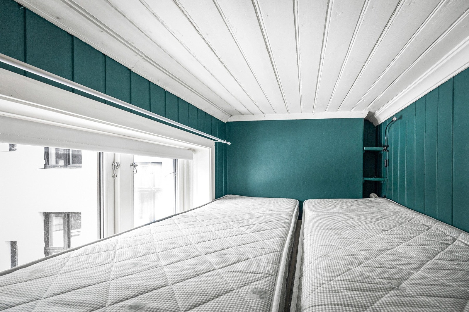 En funksjonell sovealkove plassert over garderoben. Galleribilde