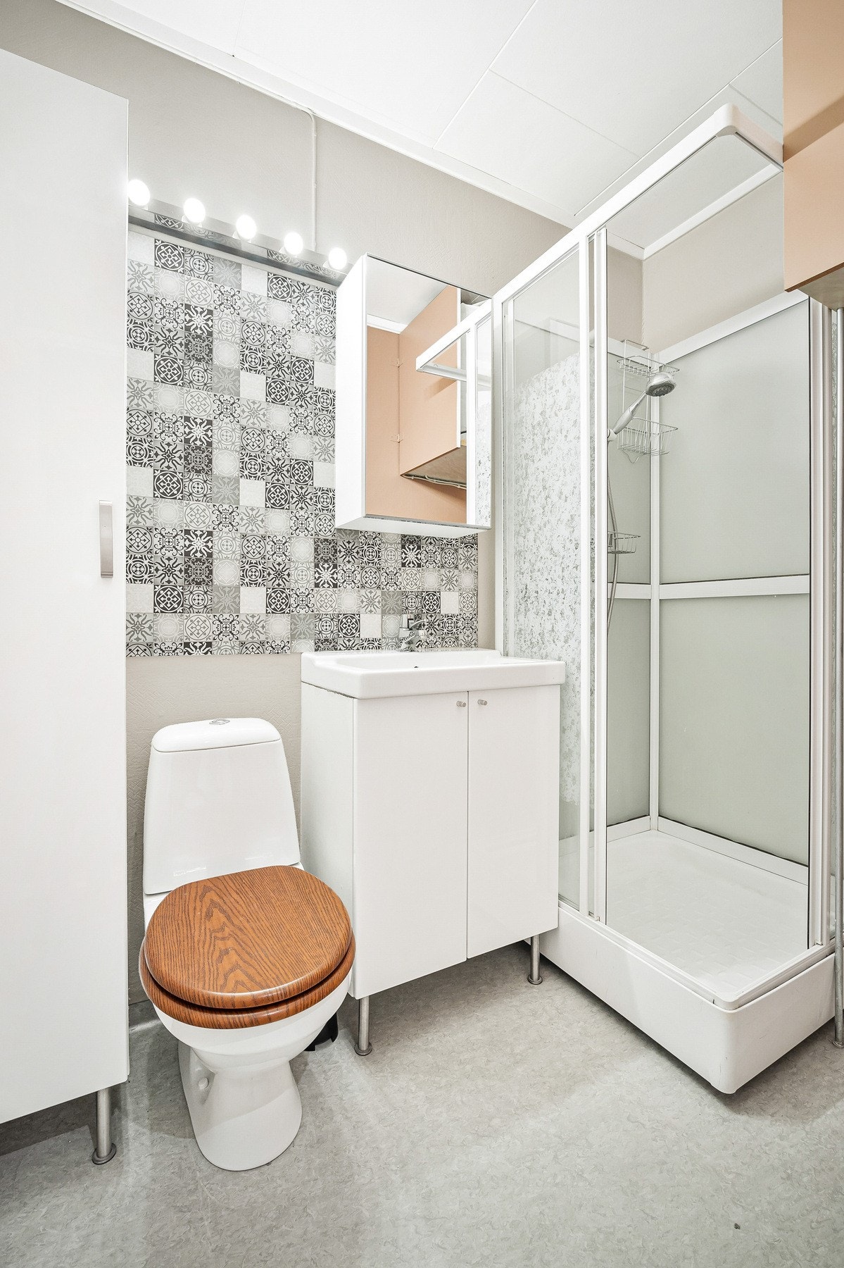 Stilrent bad med opphengt speilskap, servant med underskap, frittstående skap og dusjkabinett. Det er også opplegg til vaskemaskin. Galleribilde