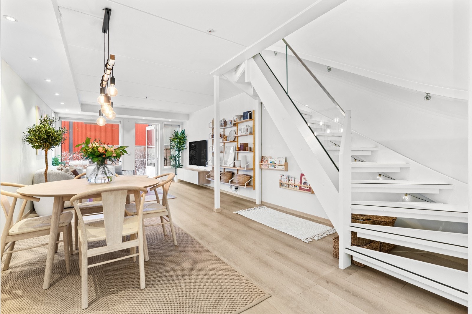 Innvendig trapp av treverk med rekkverk av glass og metall samt håndløper av treverk Galleribilde