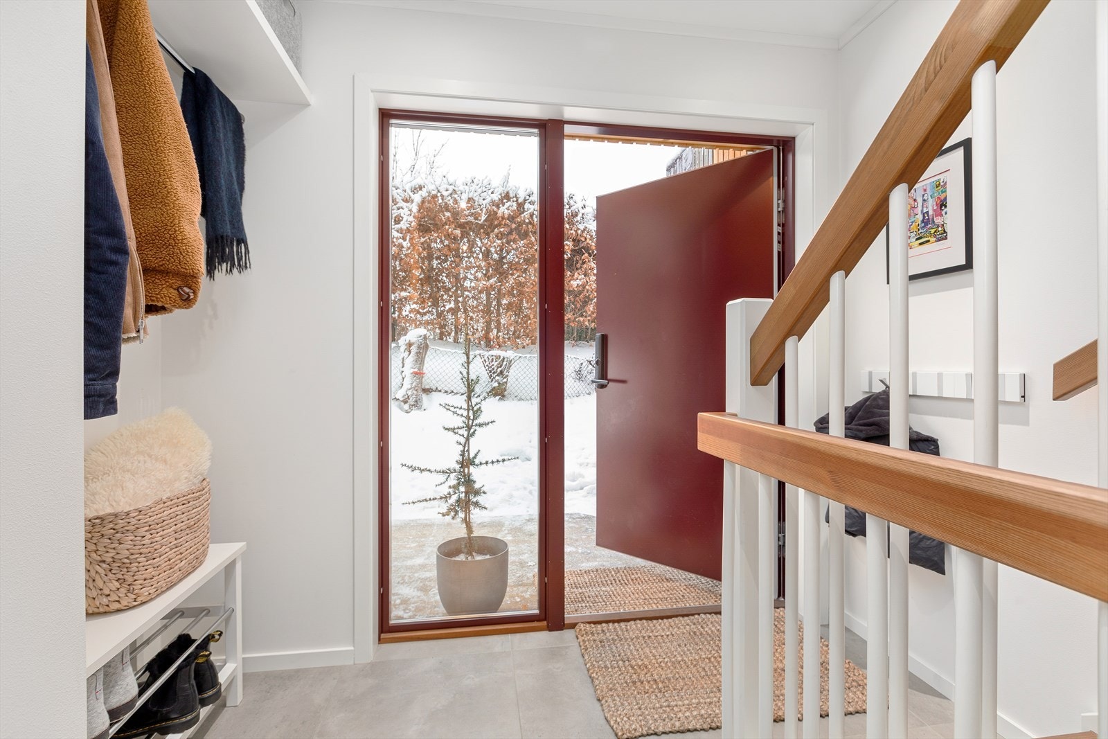 Flislagt entré med plass for oppheng av yttertøy og sko. Galleribilde