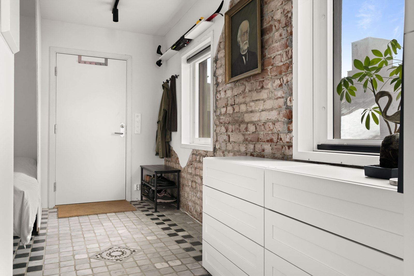 Entreen har fliser på gulvet og en sjarmerende teglsteinsvegg Galleribilde