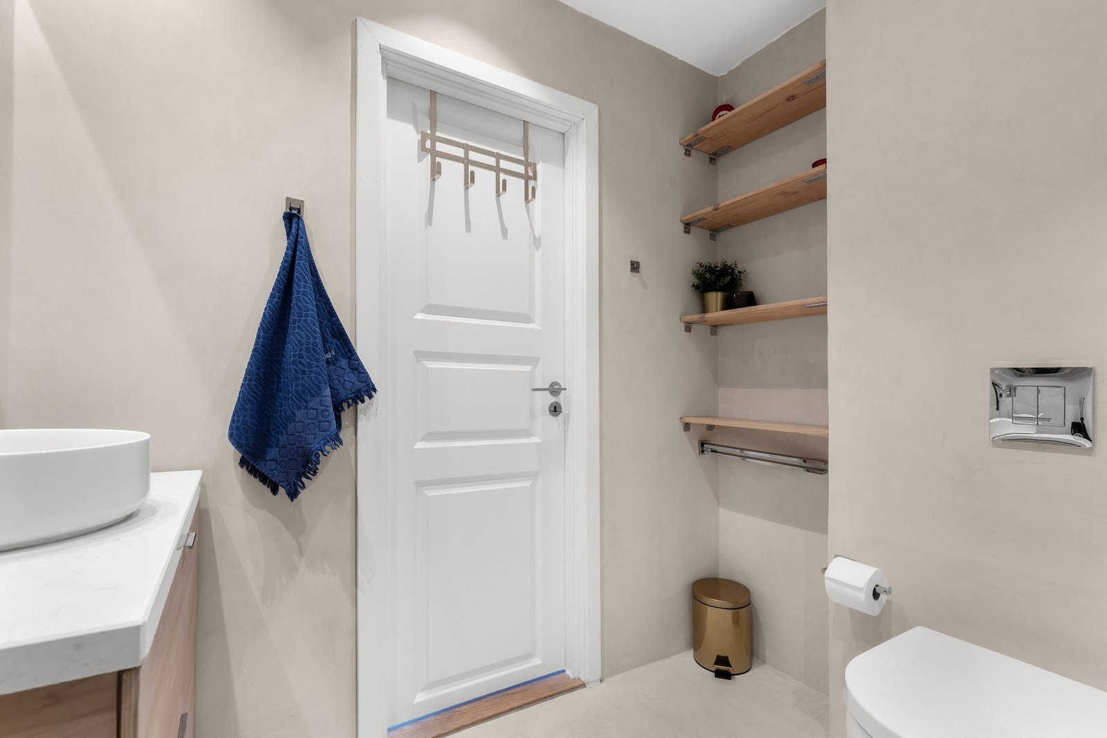 Rommet er utstyrt med servantinnredning med ovenpåliggende servant, vegghengt speilskap, regndusj og innadslående dusjdør i glass Galleribilde