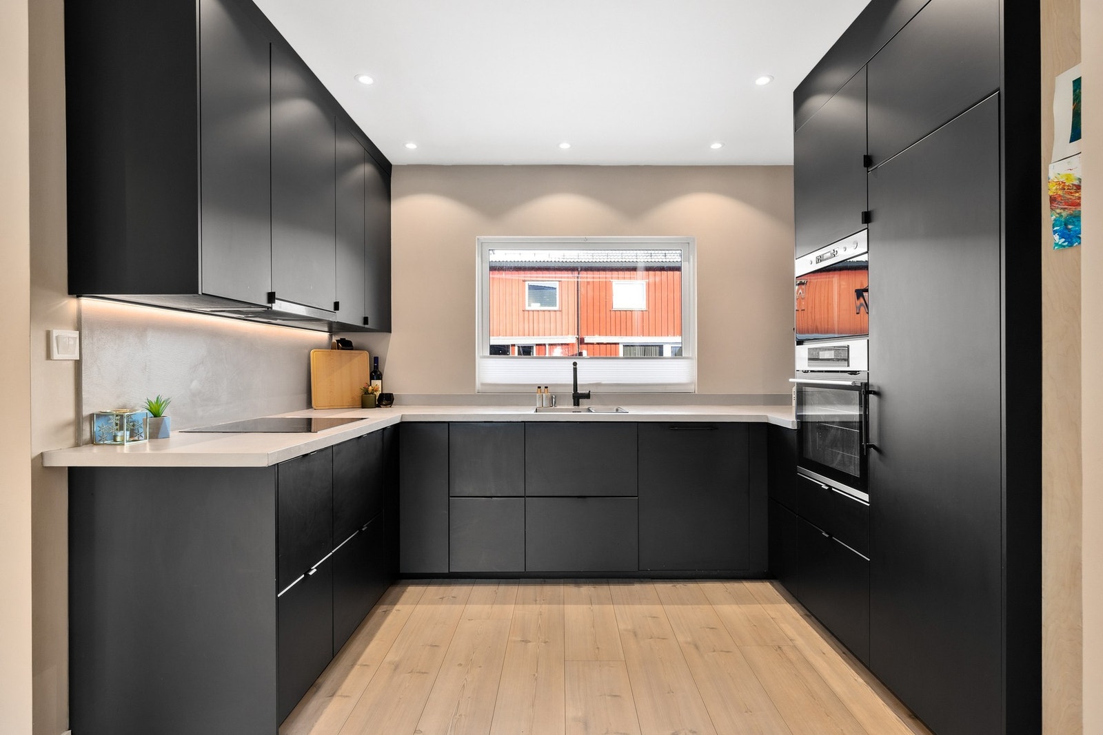 Pen og moderne kjøkkeninnredning fra IKEA med slette, sorte fronter og laminat benkeplate Galleribilde