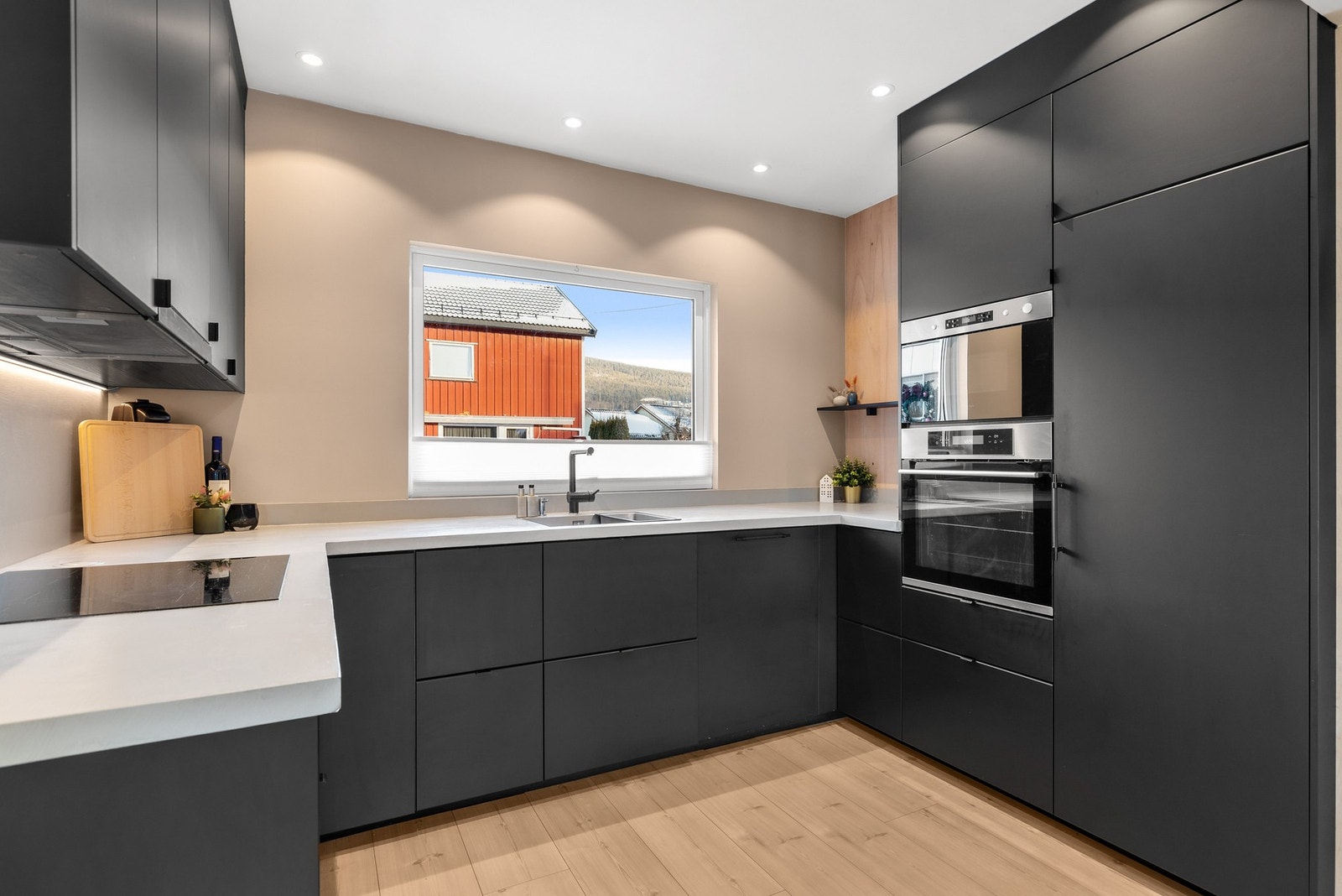 Kjøkkenet har integrerte hvitevarer, herunder stekeovn, platetopp, kjøleskap, micro og oppvaskmaskin Galleribilde