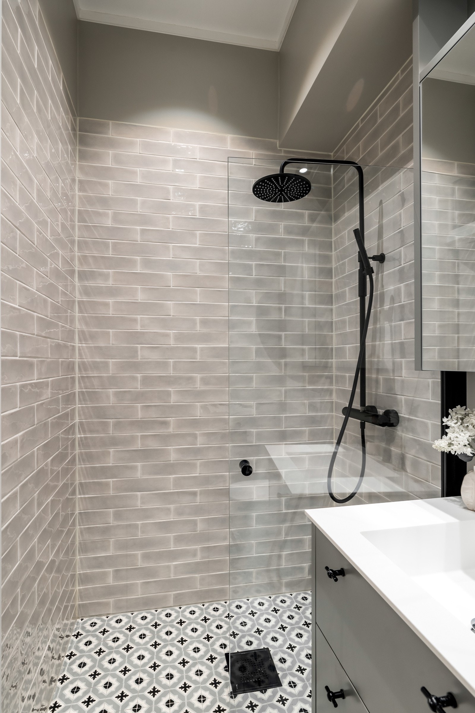 Badet er utstyrt med et vegghengt toalett og et dusjhjørne med glassvegg og regnfallsdusj. Galleribilde