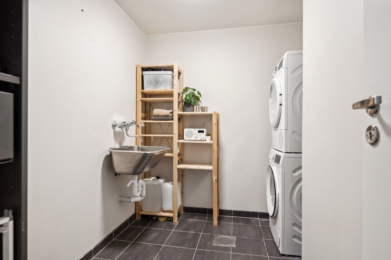 Praktisk vaskerom med fliser og varme i gulv. Malte flater på vegger. Rommet har skyllekum og opplegg for oppvaskmaskin. Balansert ventilasjon med avtrekksventil og luftespalte under dør. Galleribilde