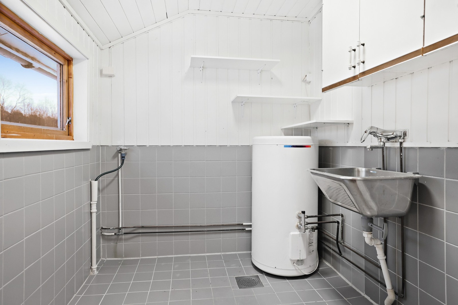 Vaskerommet har flislagt gulv med gulvvarme og vegger belagt med plater og fliser. Galleribilde