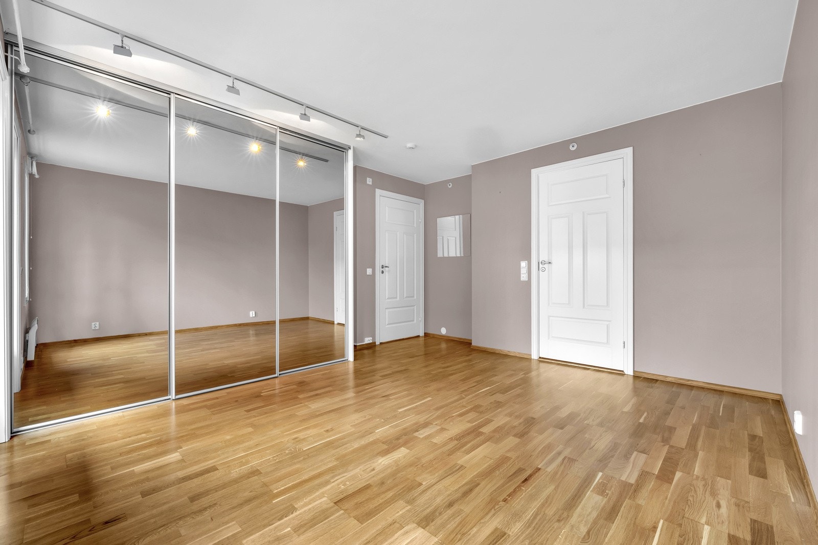 På skyvedørsgarderoben er det store speilflater som gjør rommet luftigere. Galleribilde