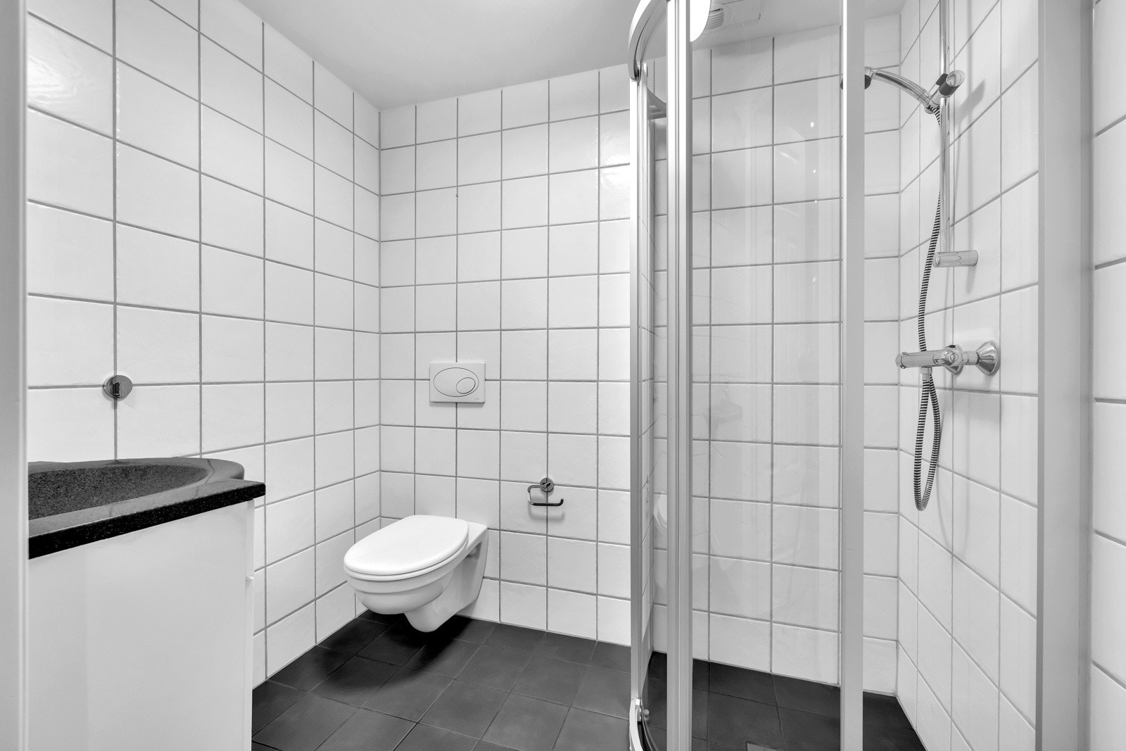 Baderom 2 er originalt fra byggeåret og har flislagt gulv og vegger. Badet er utstyrt med vegghengt servantskap med ett-greps armatur, vegghengt speil med overbelysning og dusjhjørne med innfellbare glassdører og hånddusj, og vegghengt toalett. Galleribilde