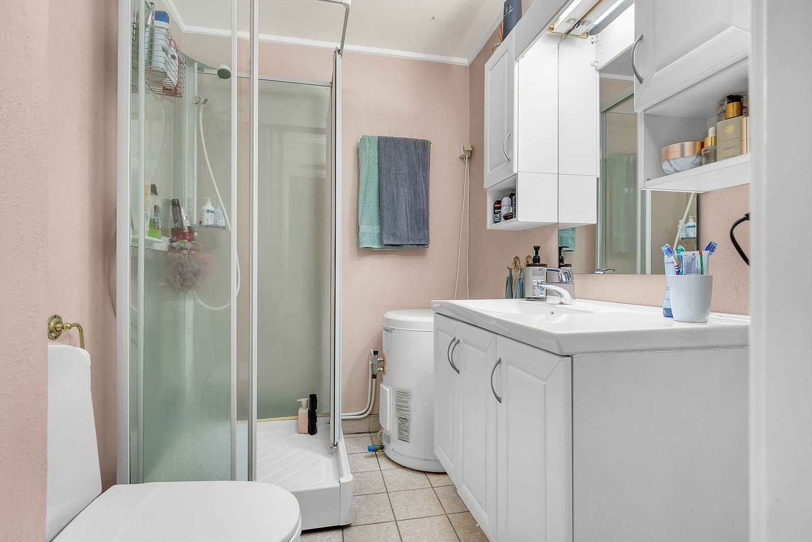 Praktisk bad utstyrt med dusjkabinett, toalett, servantskap og varmtvannsbereder. Galleribilde