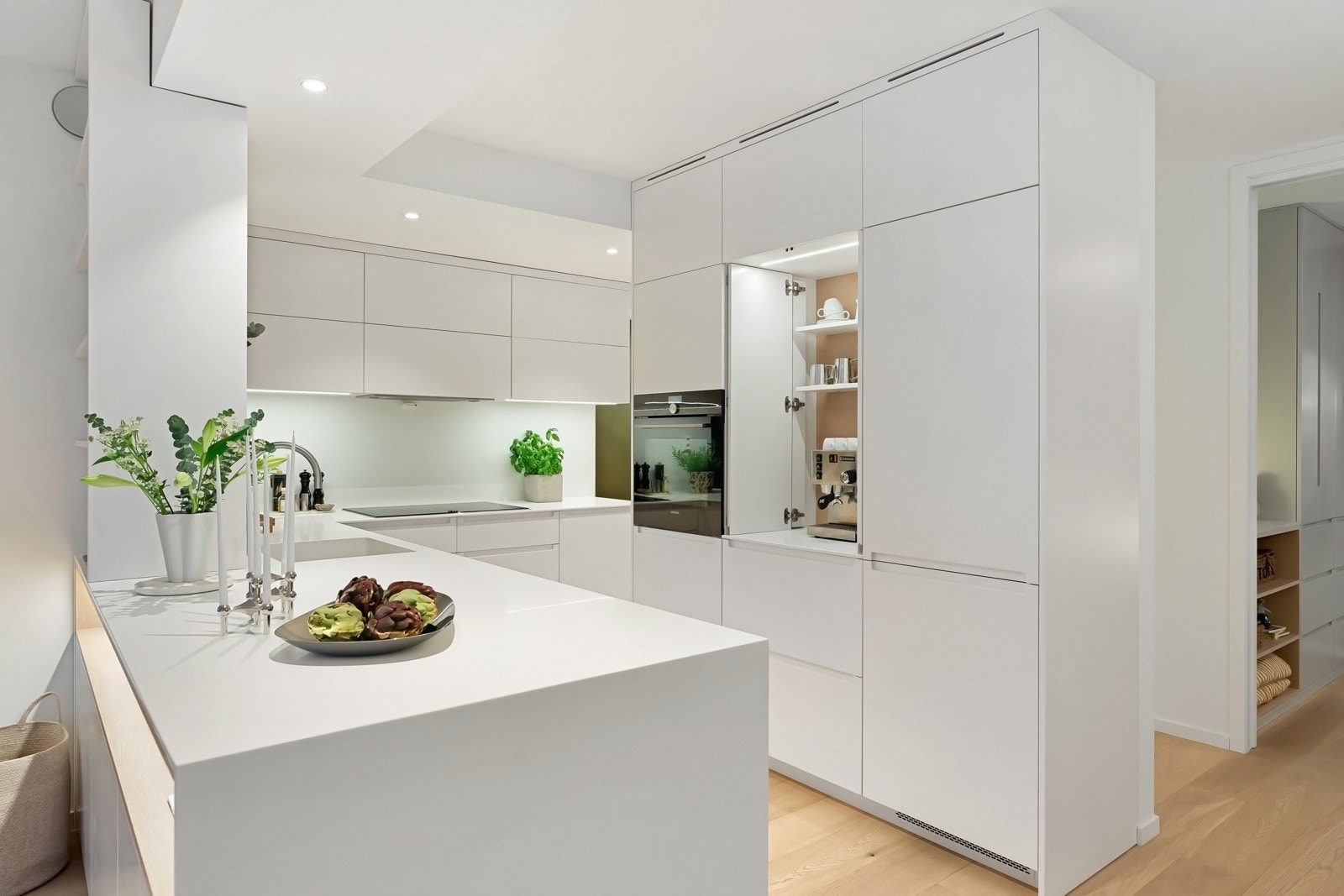 Kjøkkenet ble plassbygget av møbelsnekker i 2018, utført i glatte fronter med solid benkeplate i Corian Galleribilde