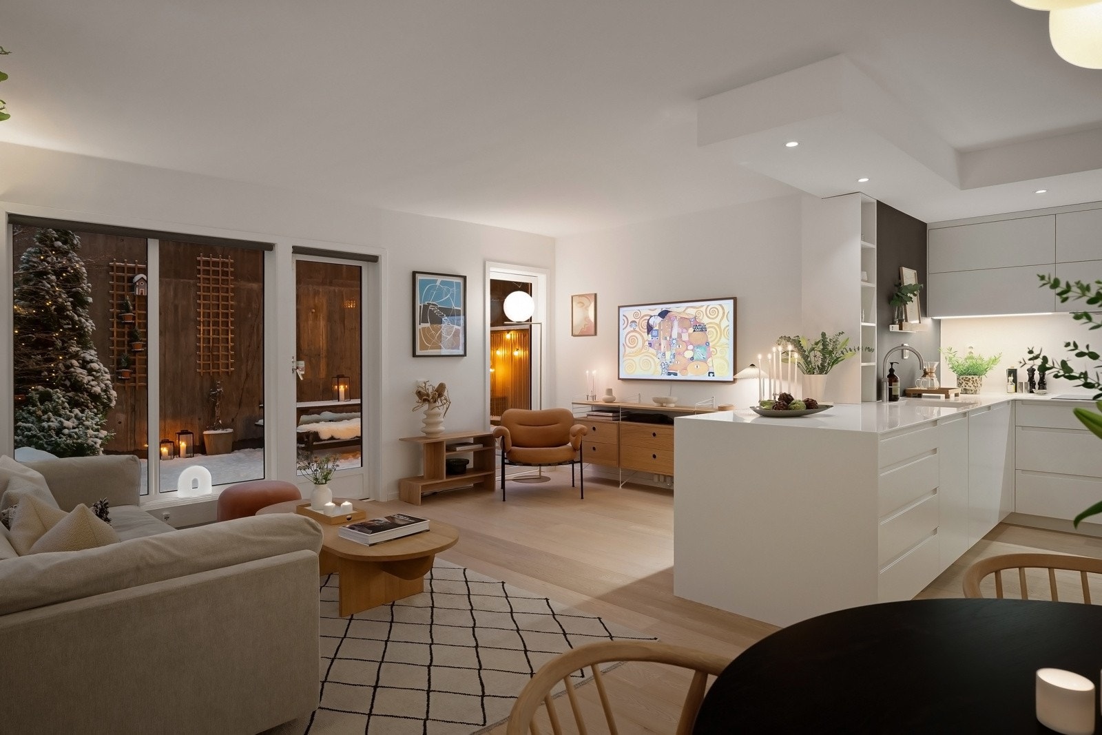 Stuen ligger i en åpen løsning mot leilighetens kjøkken, noe som gjør dette til en svært sosial sone Galleribilde