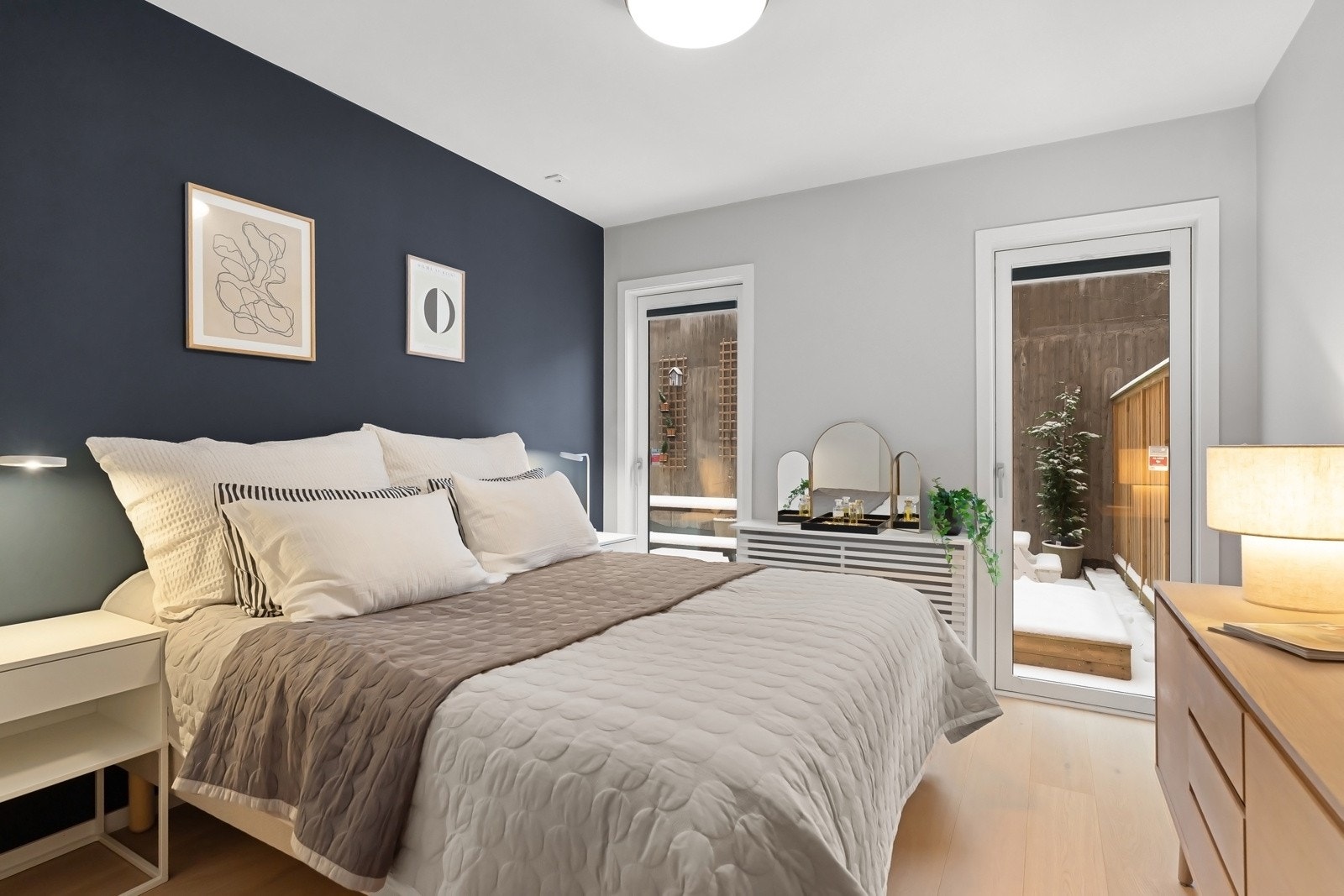 Leilighetens hovedsoverom er av god størrelse, med plass til dobbeltseng, nattbord og oppbevaringsmøblement Galleribilde