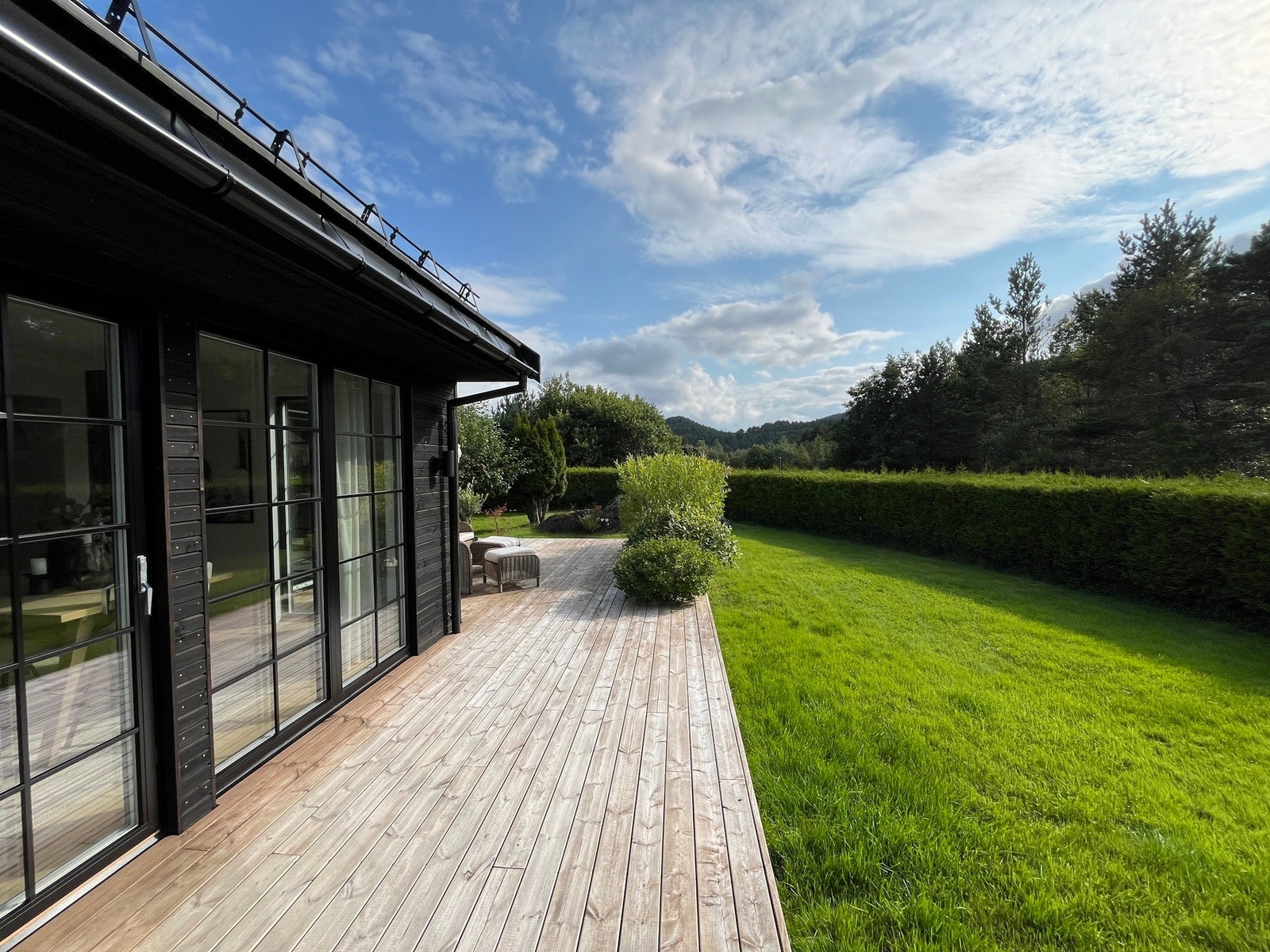 Treterrasse lagt langs husets sørside, vestside og østside. Galleribilde