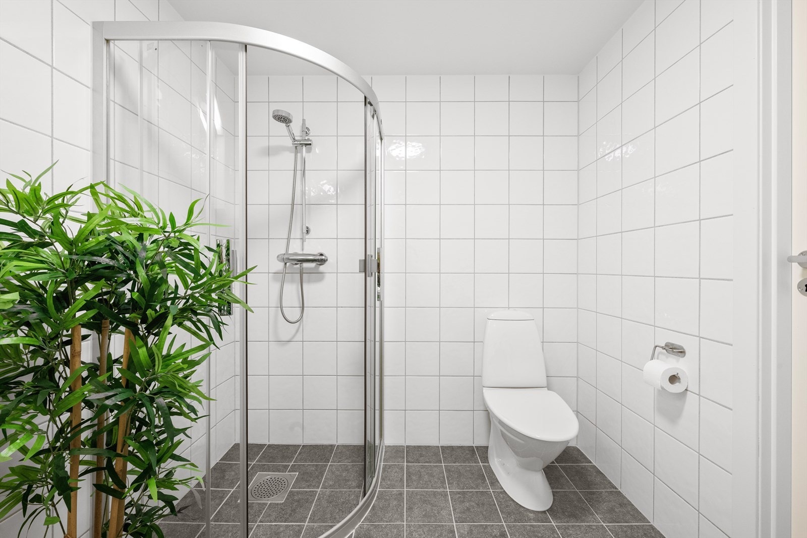 Badet er innredet med servant i baderomsmøblement, toalett og dusjhjørne. Galleribilde