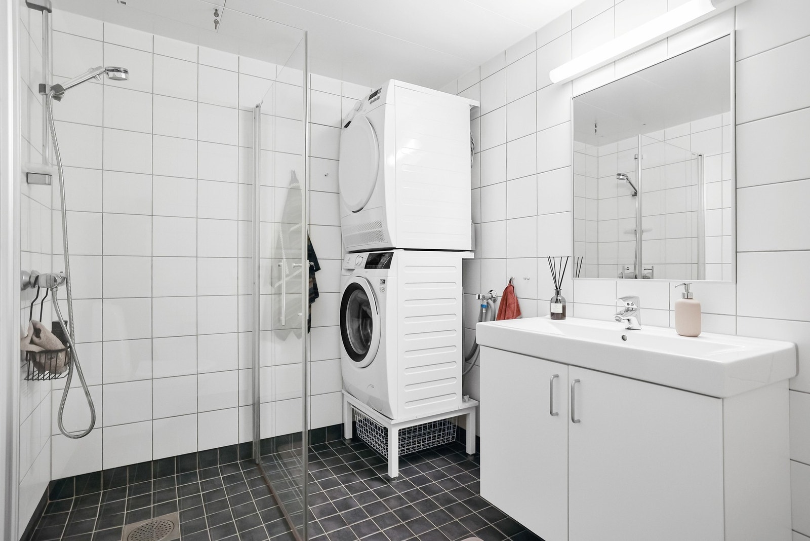 Badet er lyst med en enkel og praktisk innredning. Det er flislagt gulv med gulvvarme og vegghengt servantinnredning. Galleribilde