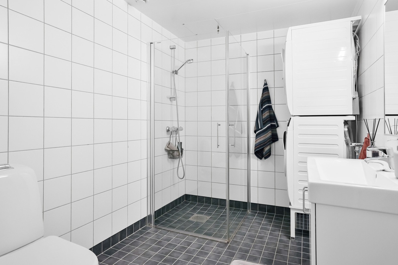 Det er dusjhjørne med dører og opplegg for vaskemaskin. Galleribilde