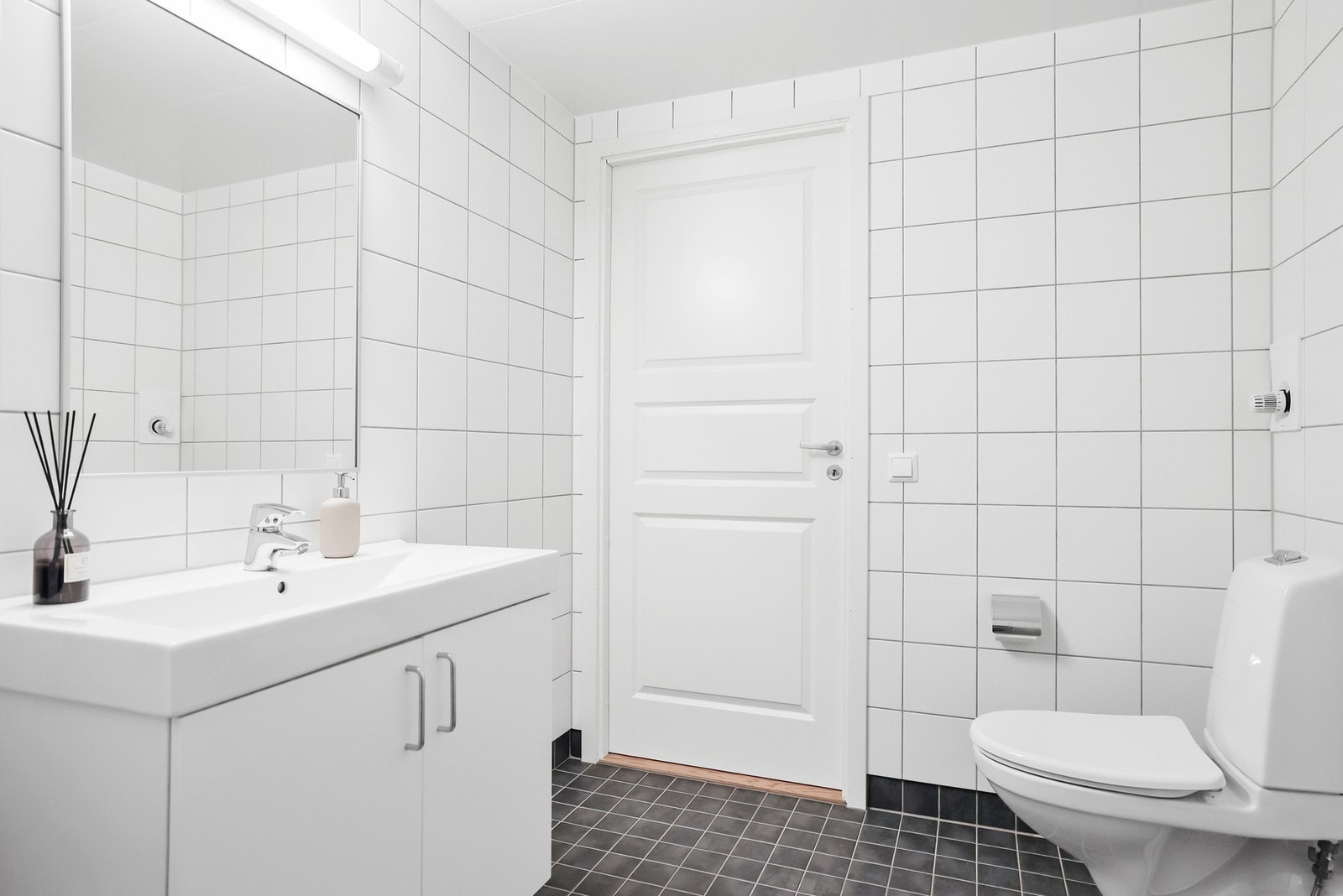 Over servantinnrdning er det speil med overlys. Det er vegghengt toalett og oppbevaringsmuligheter i servant innredning. Galleribilde