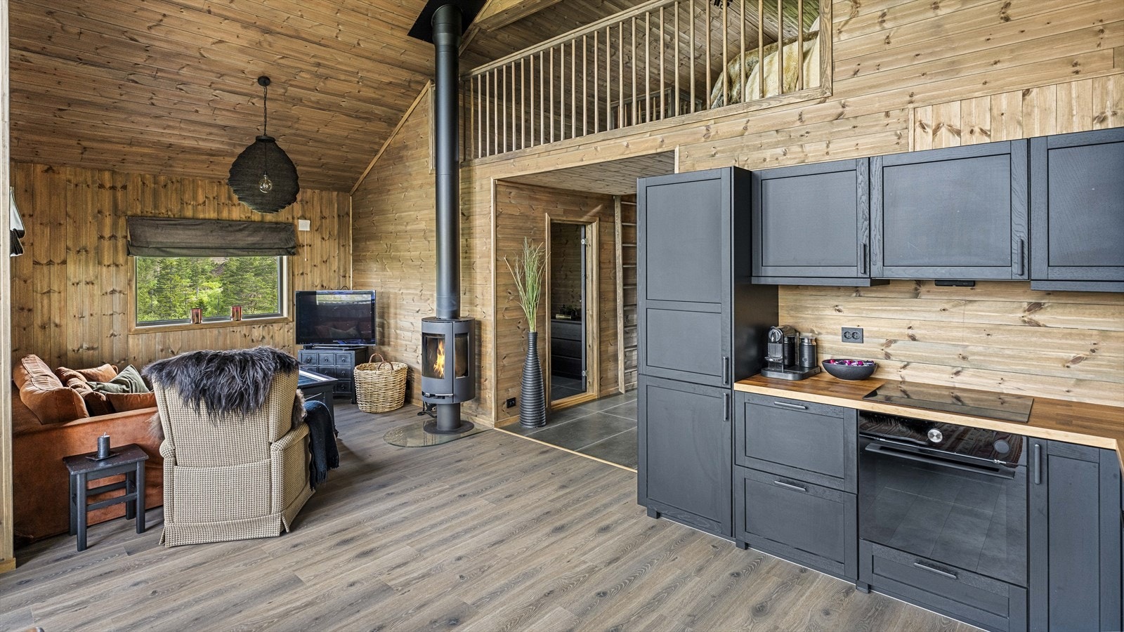 Sosialt og fint oppholdsrom med praktisk tv-krok ved peisen Galleribilde