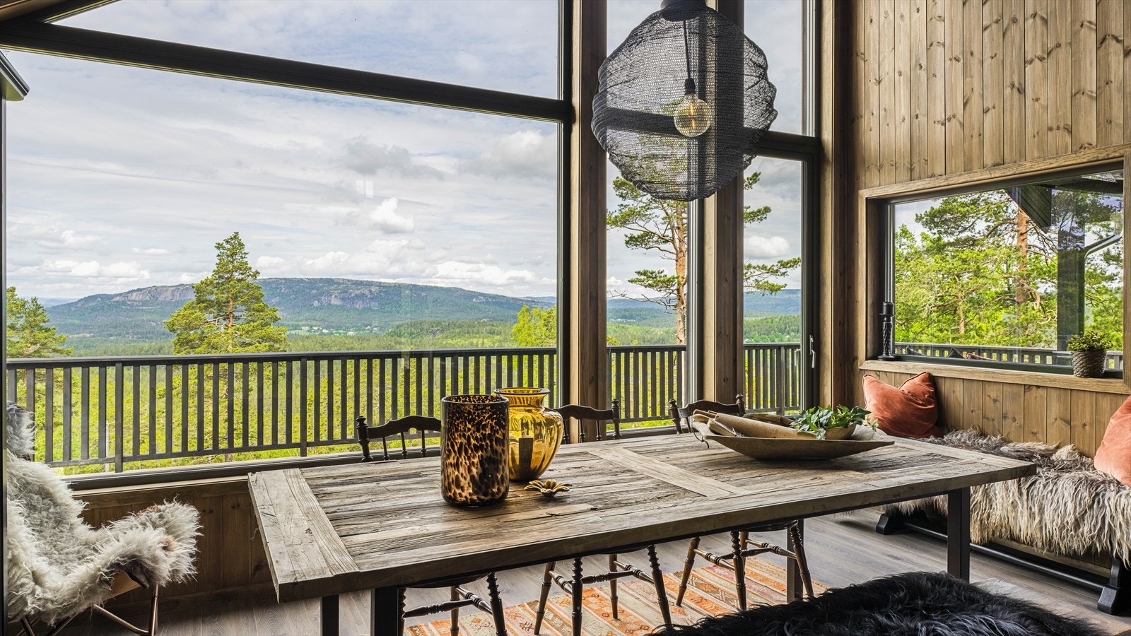 De store vindusflatene gir god med naturlig lys og drar naturen inn i hytta Galleribilde