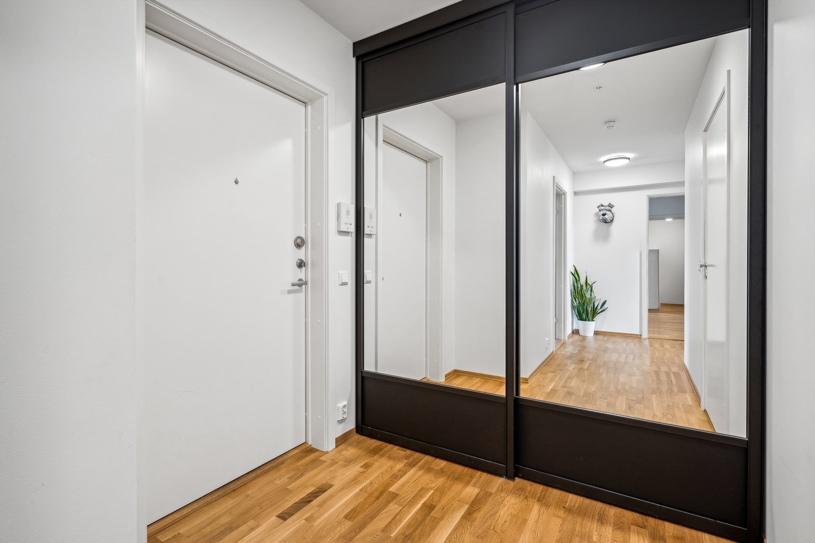 Leiligheten har en lys entré med plass til å henge fra seg i skyvedørsgarderobe. Galleribilde