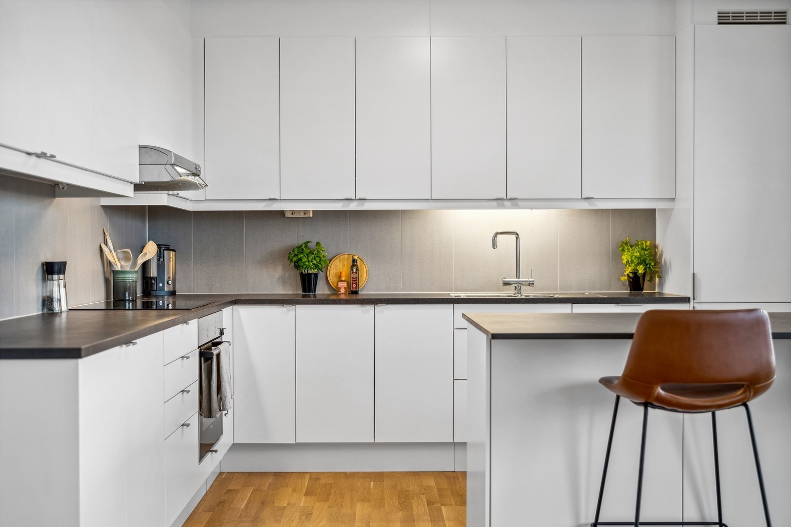 Kjøkkeninnredningen består av lyse glatte fronter, laminat benkeplate med planlimt oppvaskkum, belysning under overskap og ventilator. Galleribilde