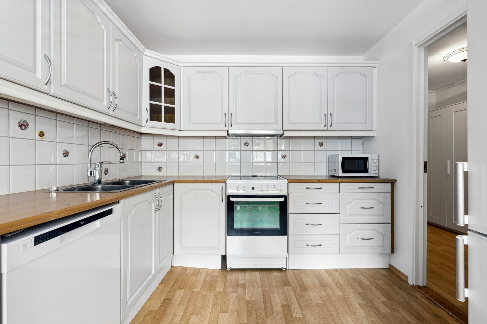 Kjøkkenet er godt praktisk med godt med skap-og benkeplass. Oppvaskmaskin, mikroovn og komfyr følger leiligheten. Galleribilde