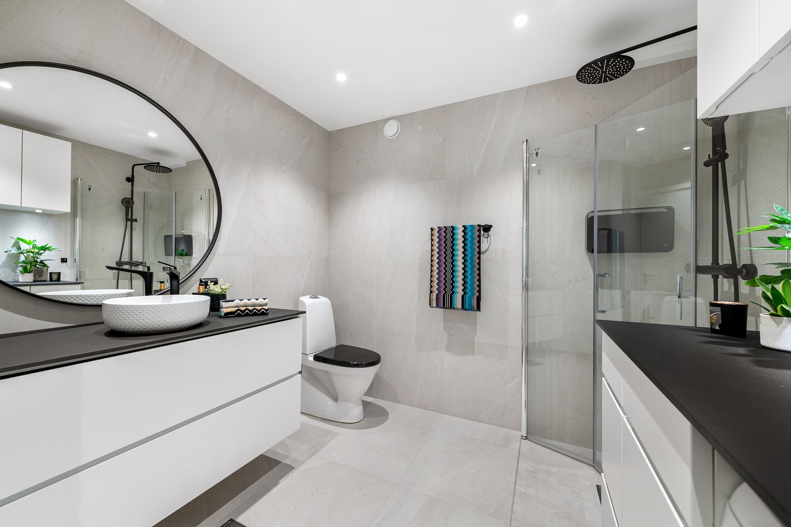 Flott bad som er oppgradert i 2019. Flislagt gulv med gulvvarme, flislagte vegger og malt tak med spotter. Hvit baderomsinnredning fra Kvik med ovenpåliggende servant med kompositt benkeplate og ett-greps armatur Galleribilde