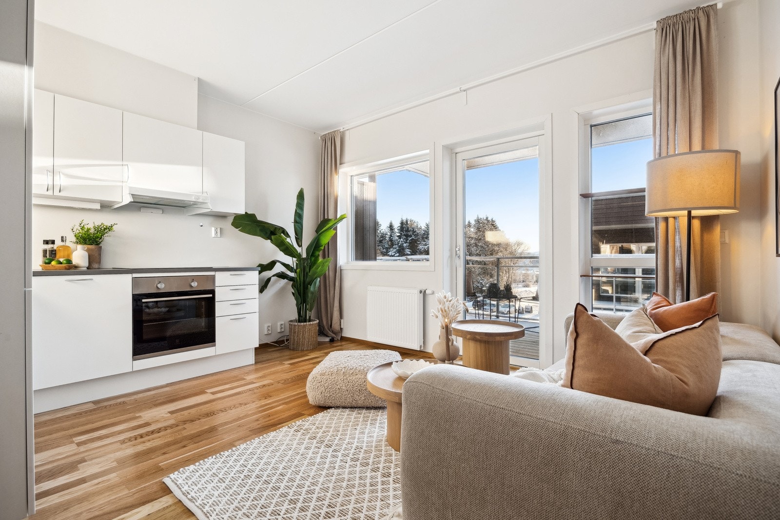 Moderne og lys stue med åpen kjøkkenløsning, store vinduer og utgang til sørvendt balkong. Et perfekt rom for avslapning og hygge! Galleribilde