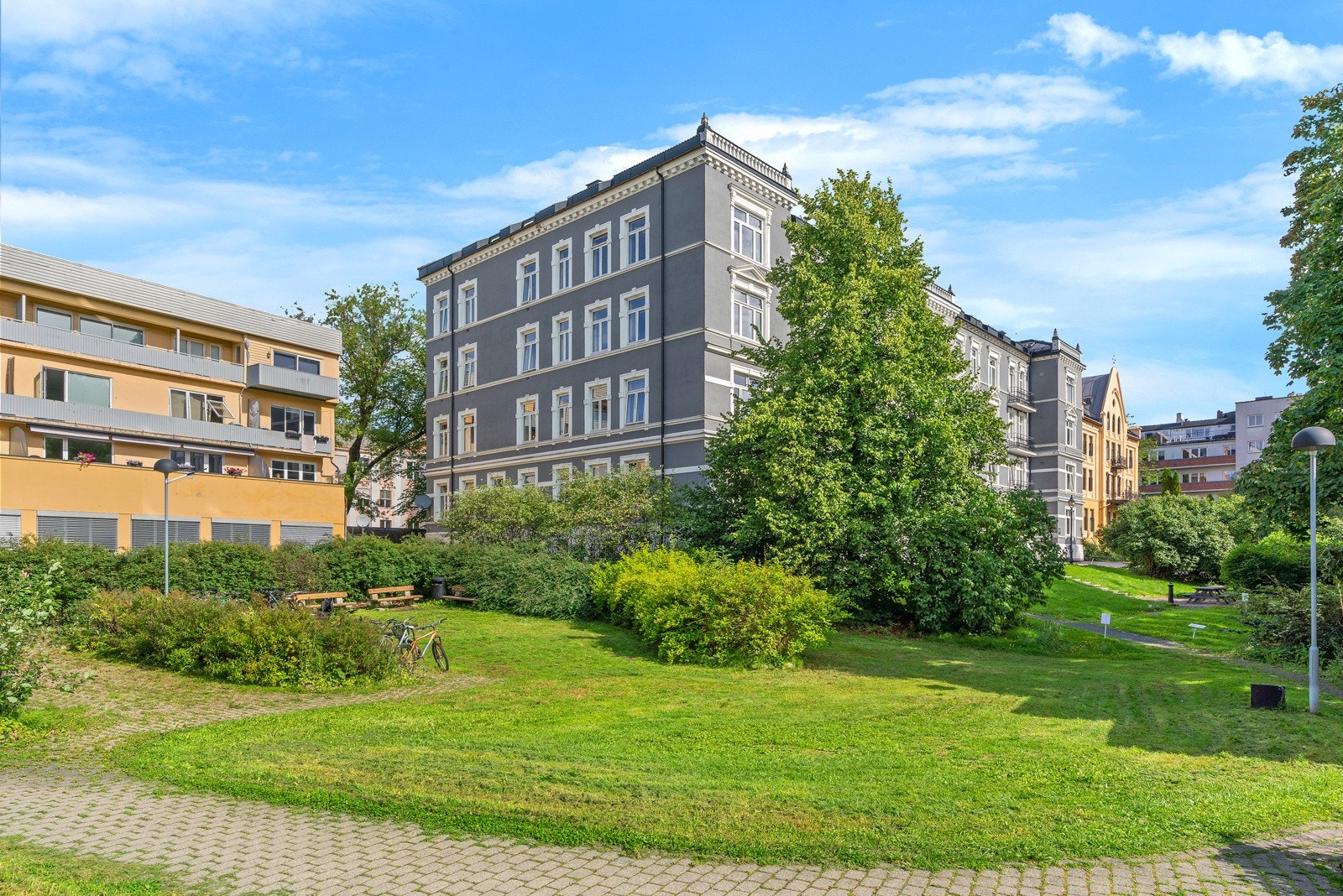 Godt opphøyet fra gateplan har beboerne tilgang til et stort, felles plenområde med sykkelparkering og sittegrupper. Galleribilde