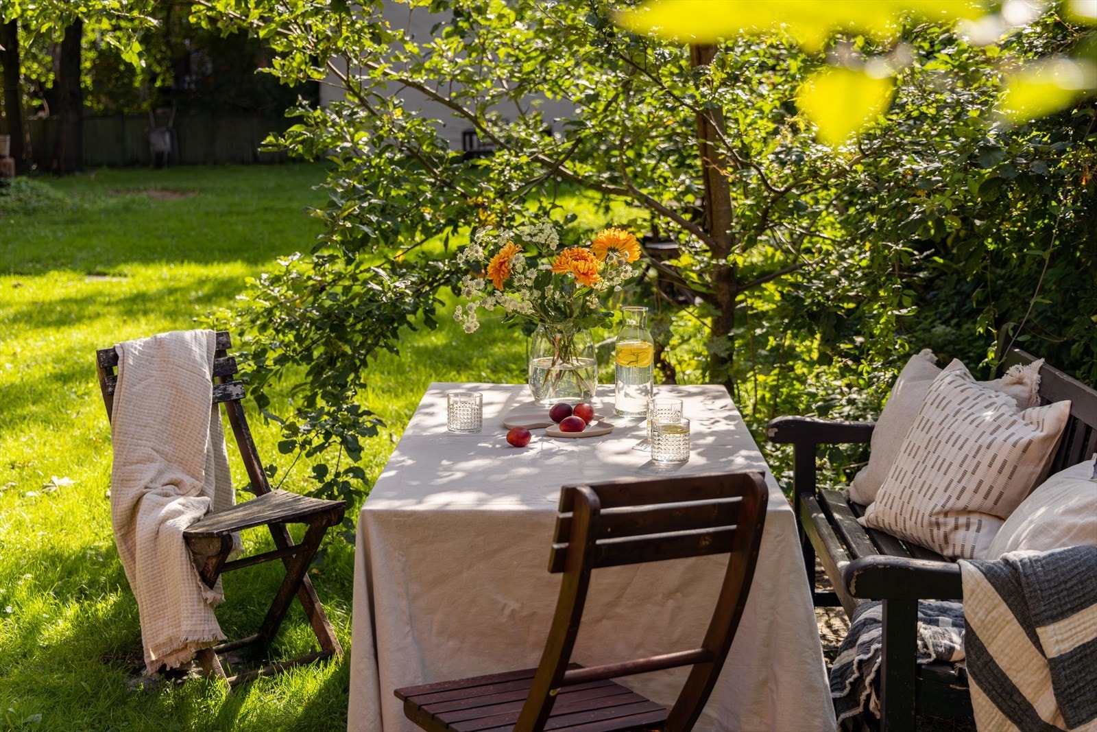 Fellesområdet byr på en idyllisk hage med grønt gress og sjarmerende sitteplasser, perfekt sted for hyggelige sammenkomster med familie, venner og naboer. Galleribilde