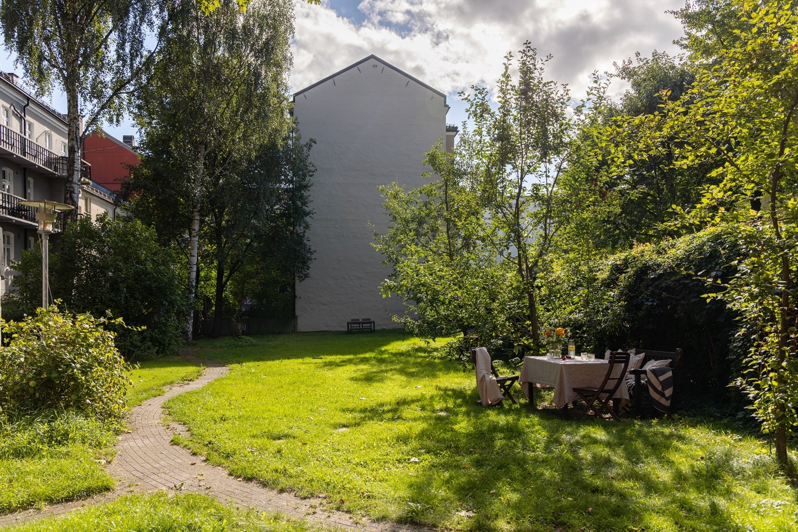 Et romslig og frodig hageområde til glede for beboerne, med god plass for sosiale aktiviteter. Galleribilde