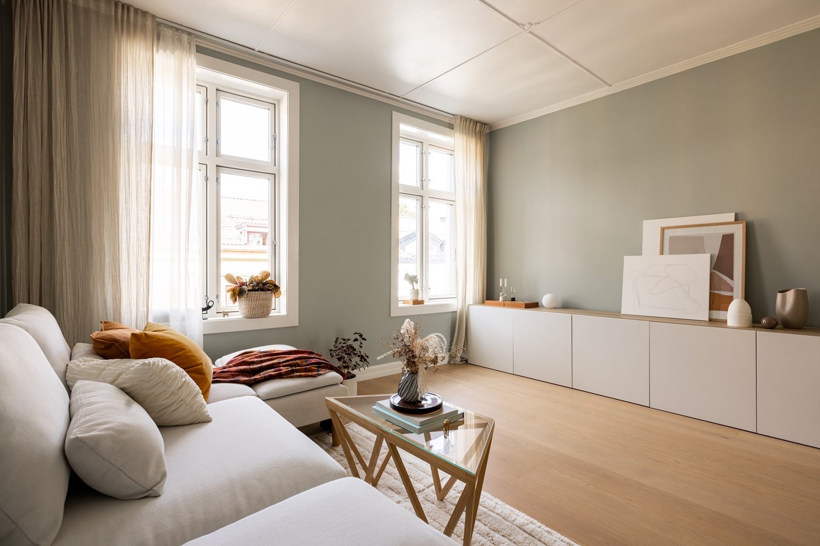 En lys og innbydende stue med nydelige detaljer og store vinduer som slipper inn rikelig med dagslys. Galleribilde