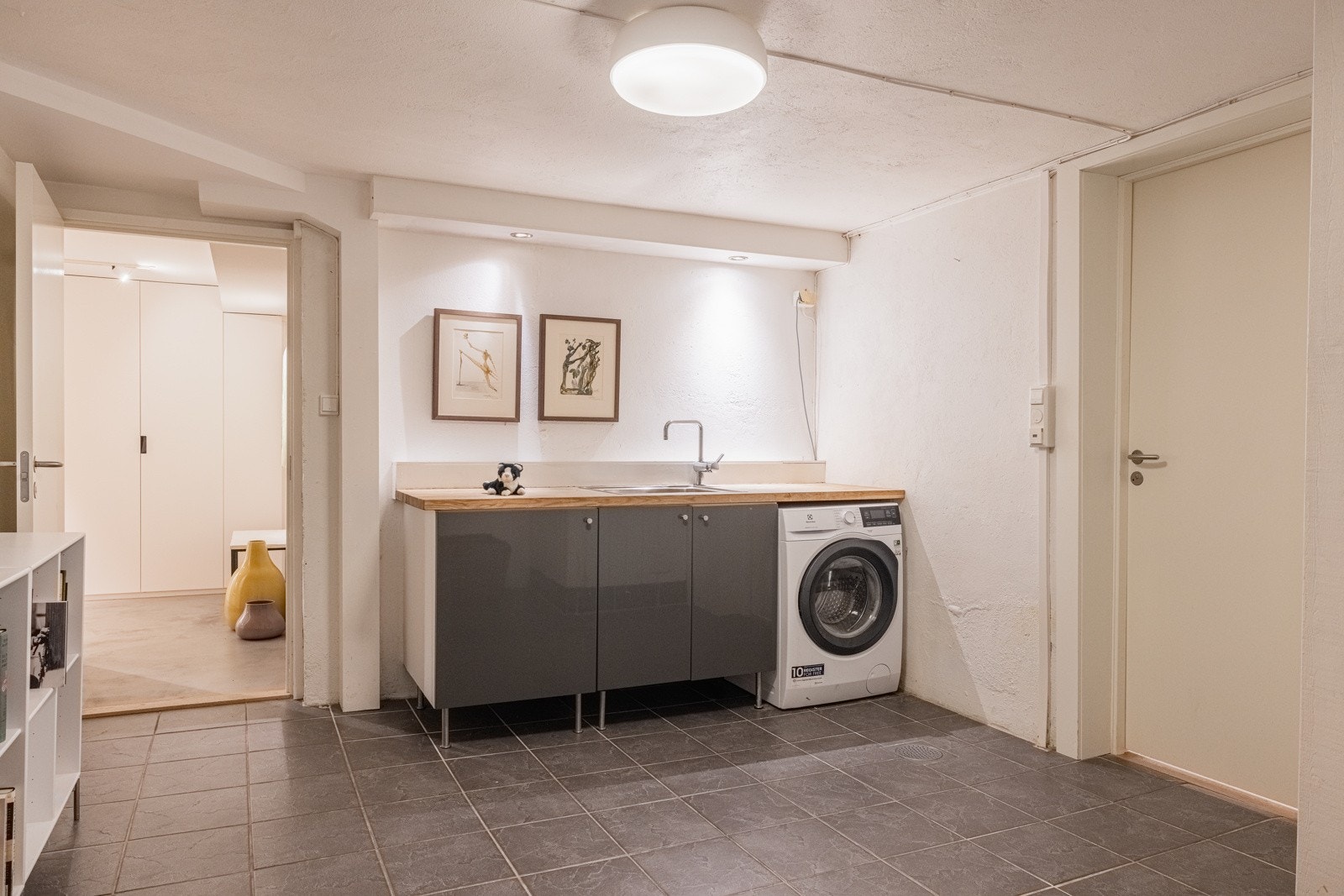 Romslig vaskerom med praktisk innredning med glatte, folierte fronter. Galleribilde