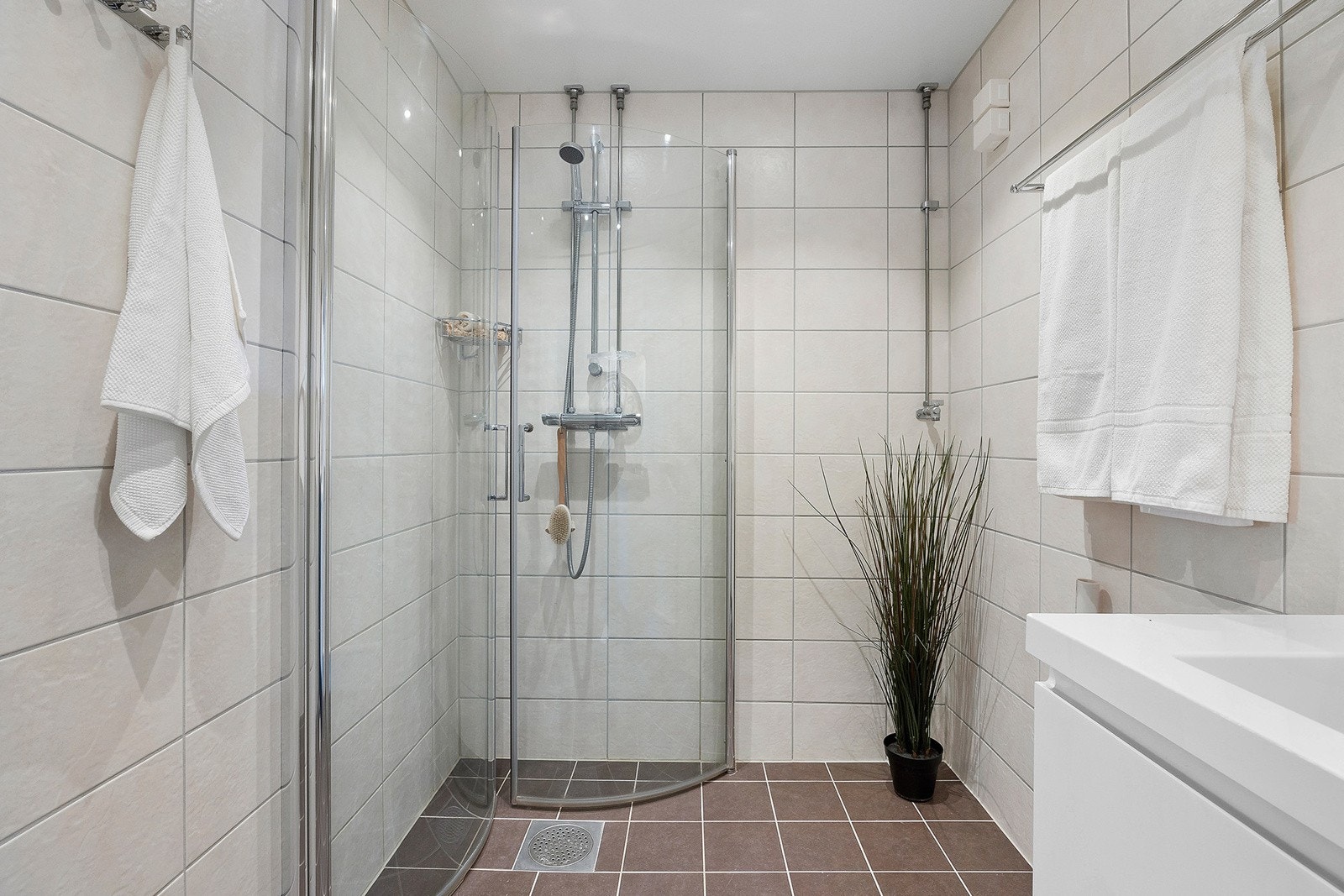 Badet består av dusjnisje med innfellbare dusjvegger samt vegghengt servant med skuffer. Galleribilde