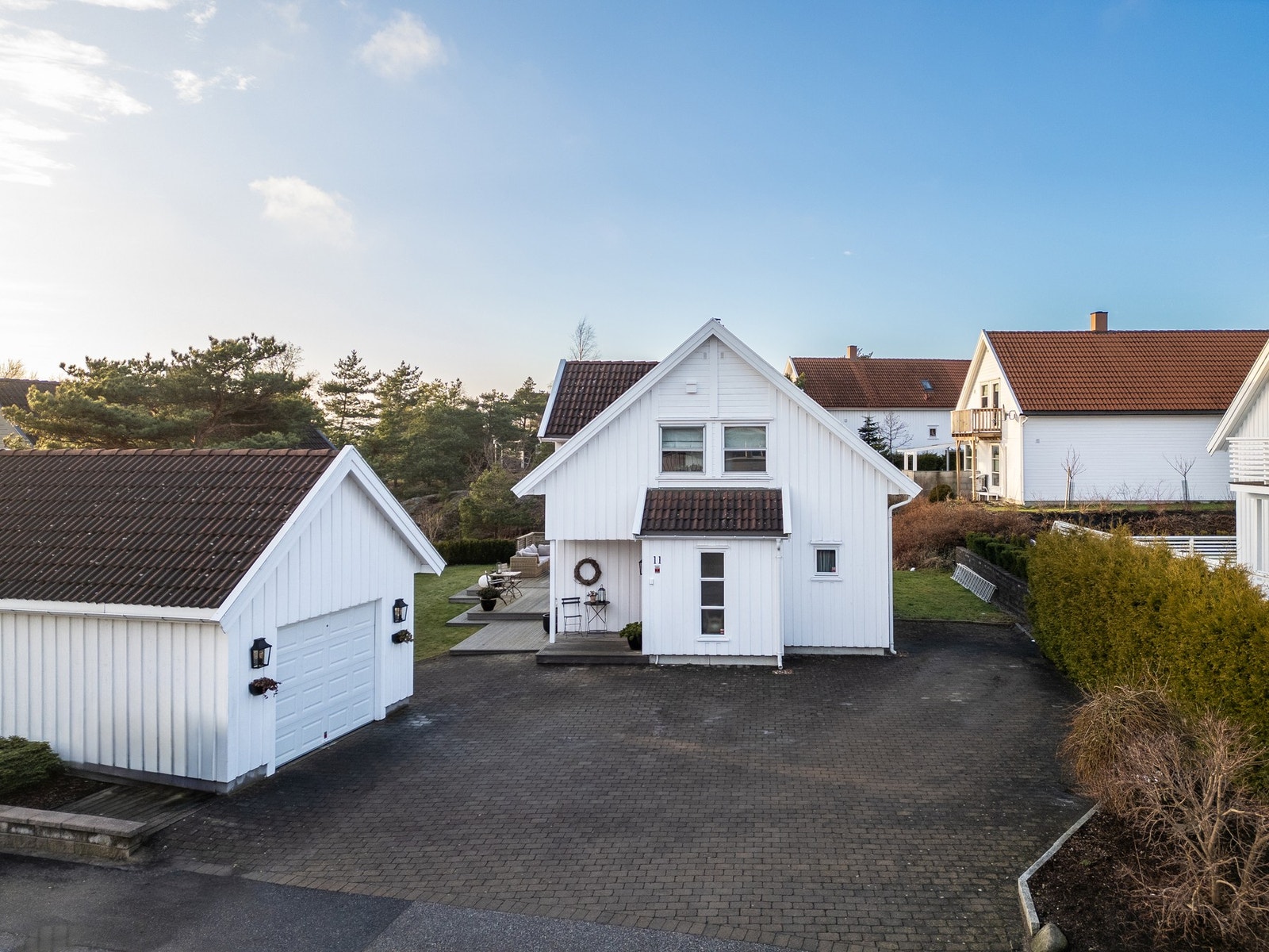 Det er godt med parkeringsplass på tomten og i garasjen. Det er montert elbillader på husveggen. Galleribilde