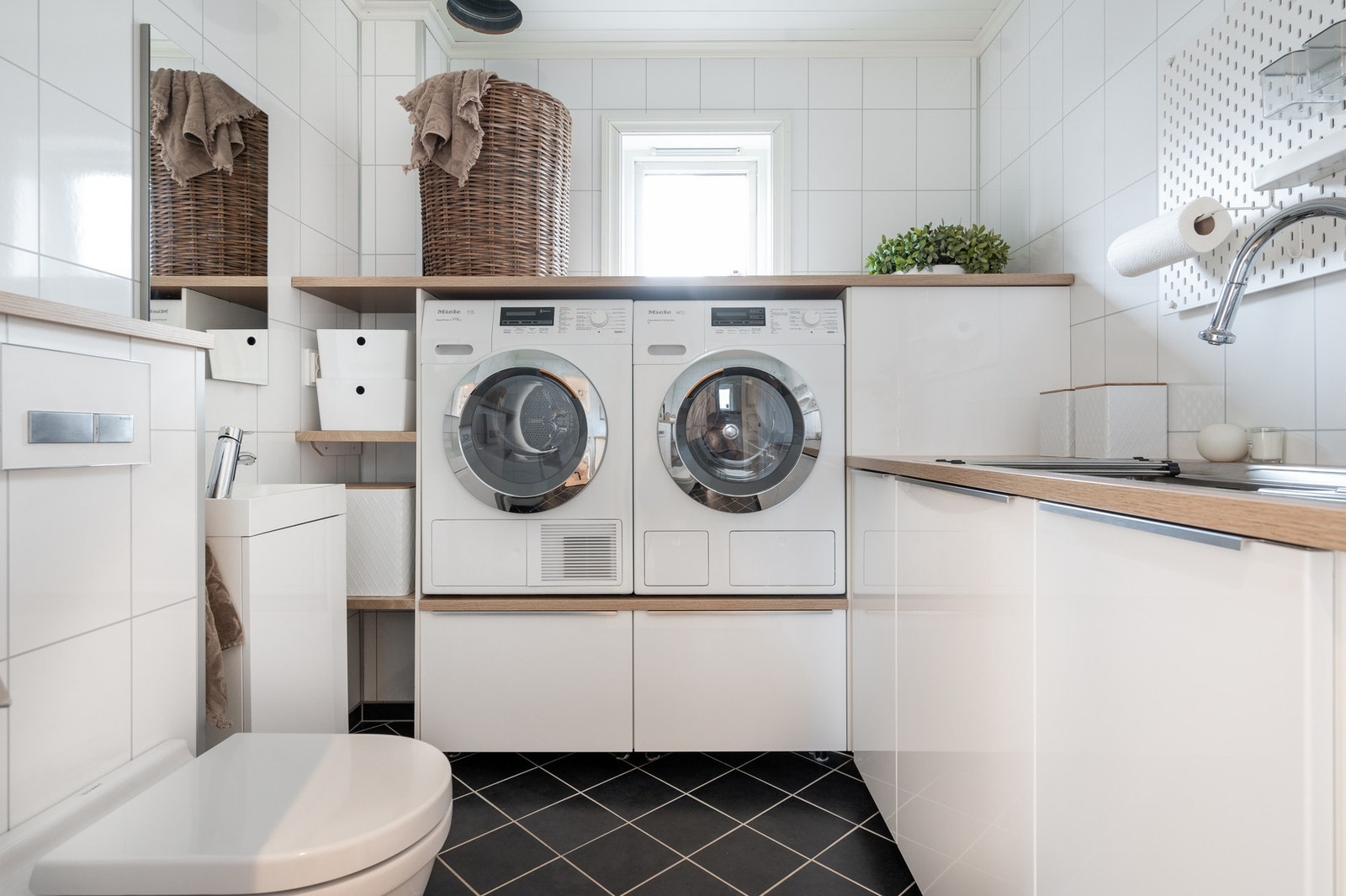 Boligen har kombinert vaske- og toalettrom i 1. etasje. I taket er det en praktisk sjakt fra badet i etasjen over. Galleribilde