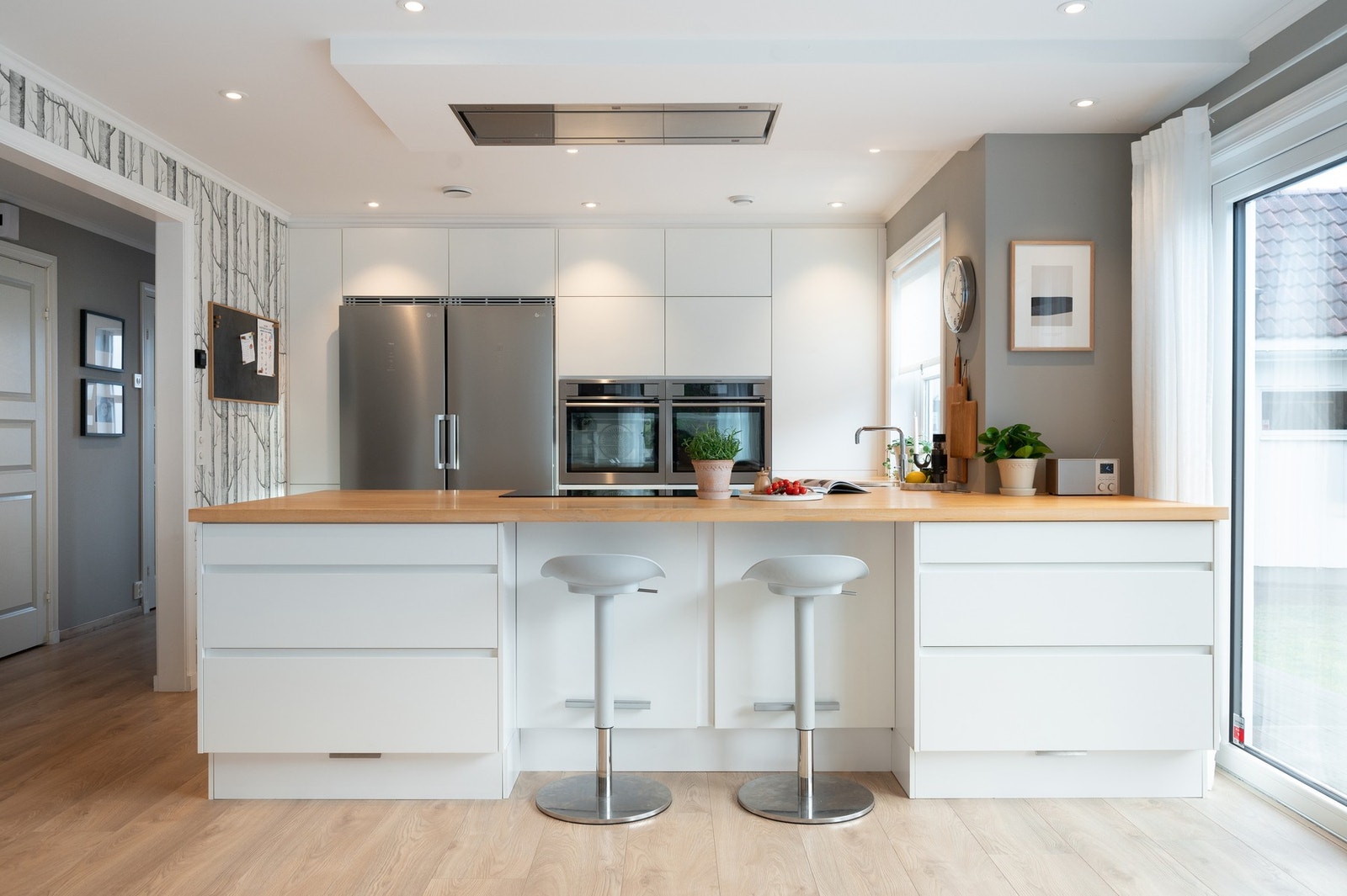 Stilren og påkostet kjøkkeninnredning fra TVIS ny i 2016 med hvite slette fronter og benkeplater av heltre Galleribilde