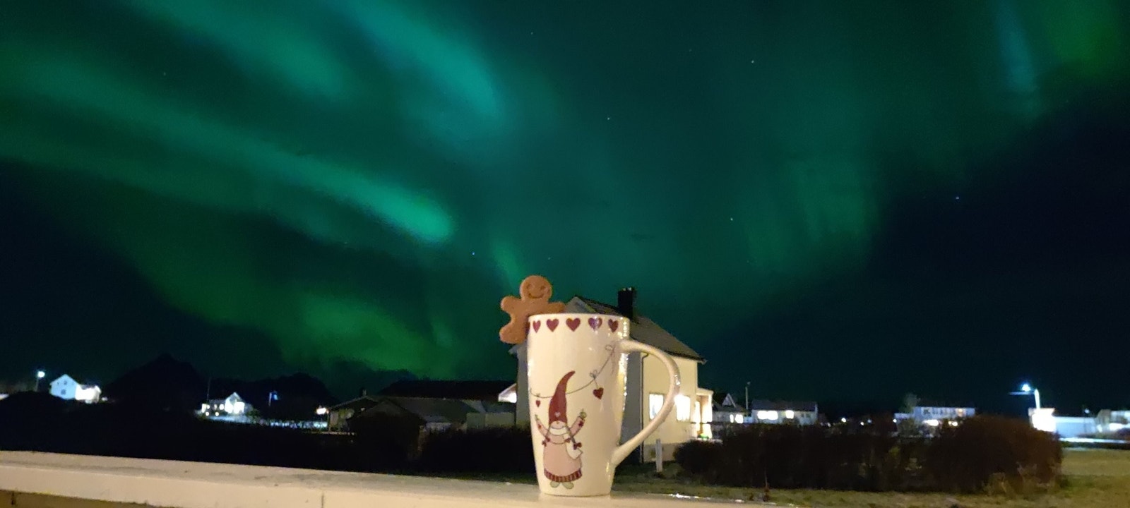 Nydelig utsikt fra veranda med nordlys og en kopp sjokolade Galleribilde