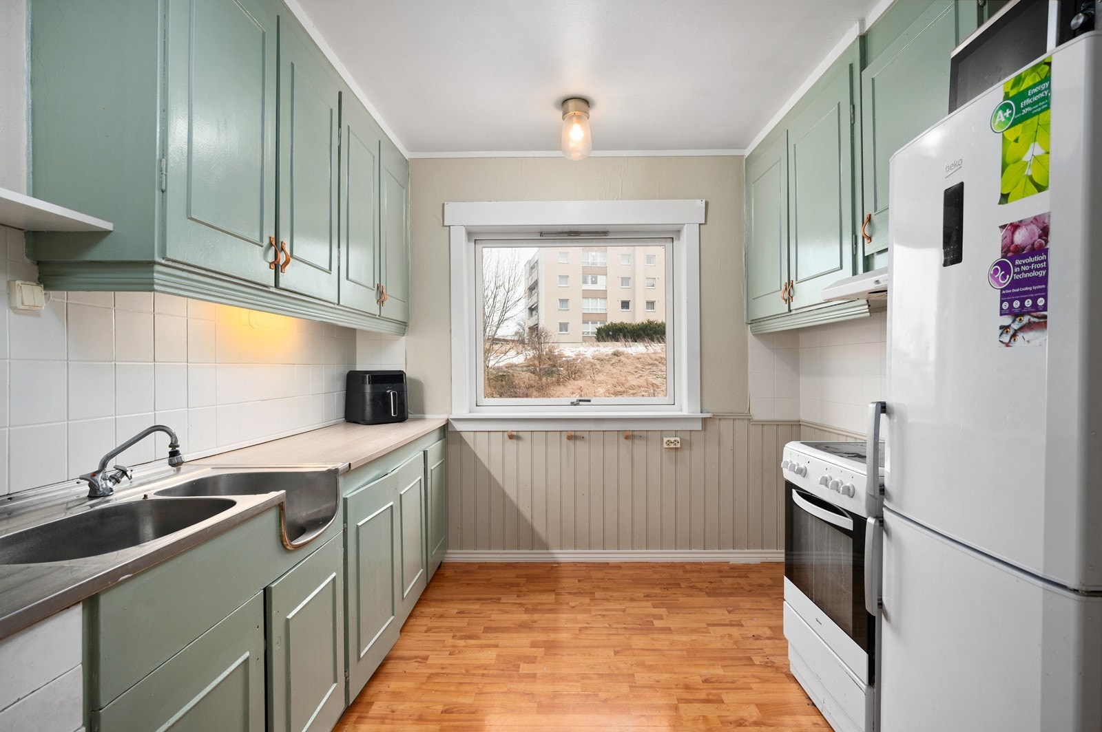 Eldre kjøkkeninnredning fra byggetiden med malte over- og underskap. Galleribilde