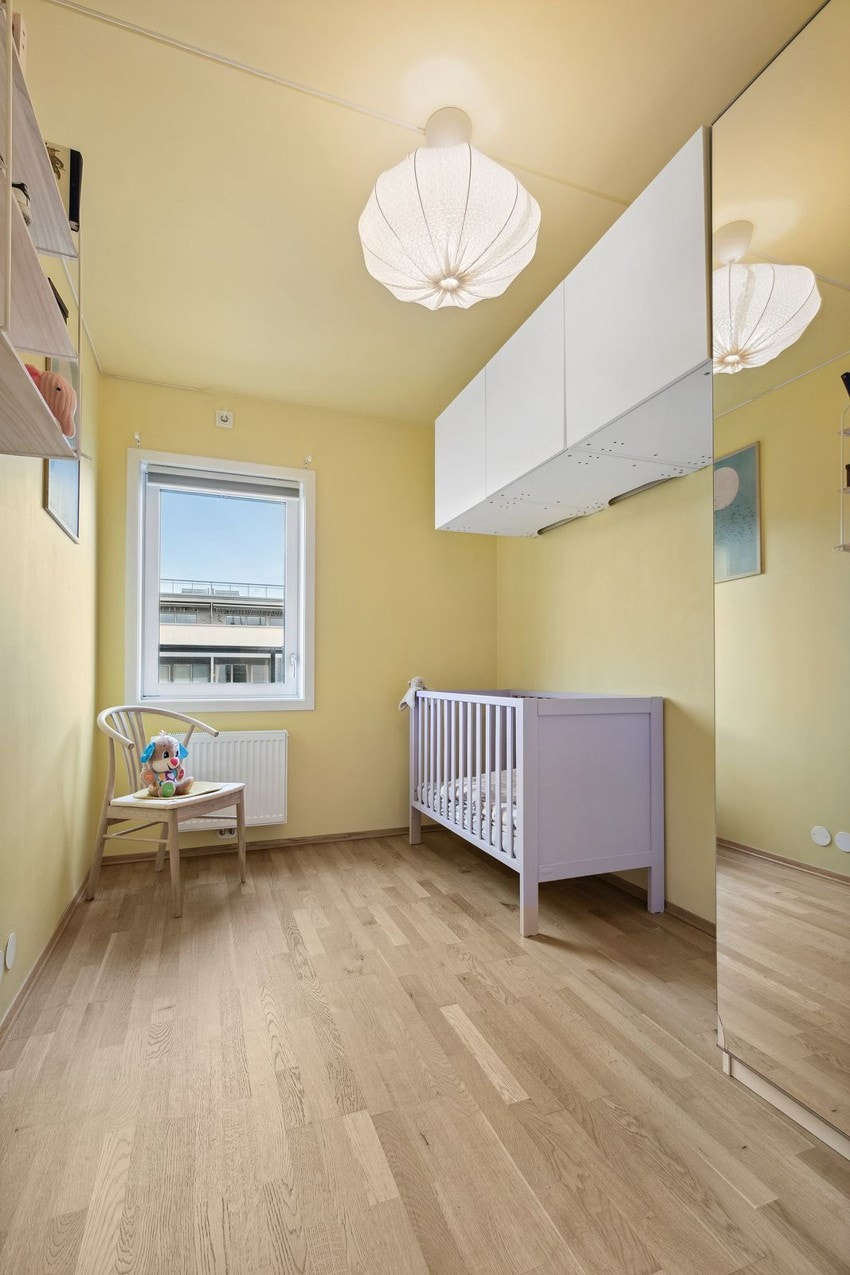 Leilighetens andre soverom er både romslig og innbydende, malt i en varm og behagelig gultone som skaper en lun og trivelig atmosfære. Galleribilde